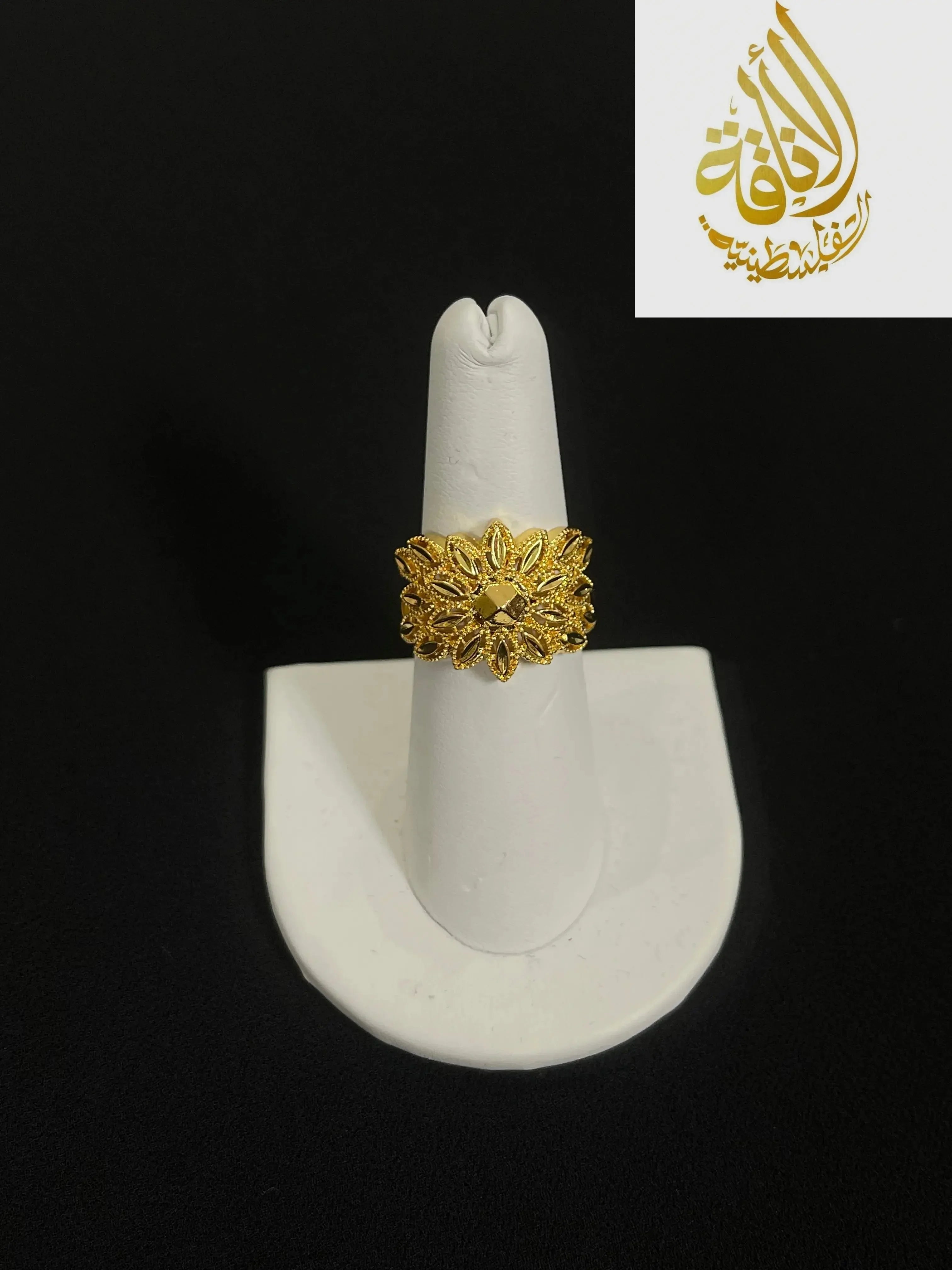 Intricate Palestinian gold jewelry set ring with floral design displayed on white stand