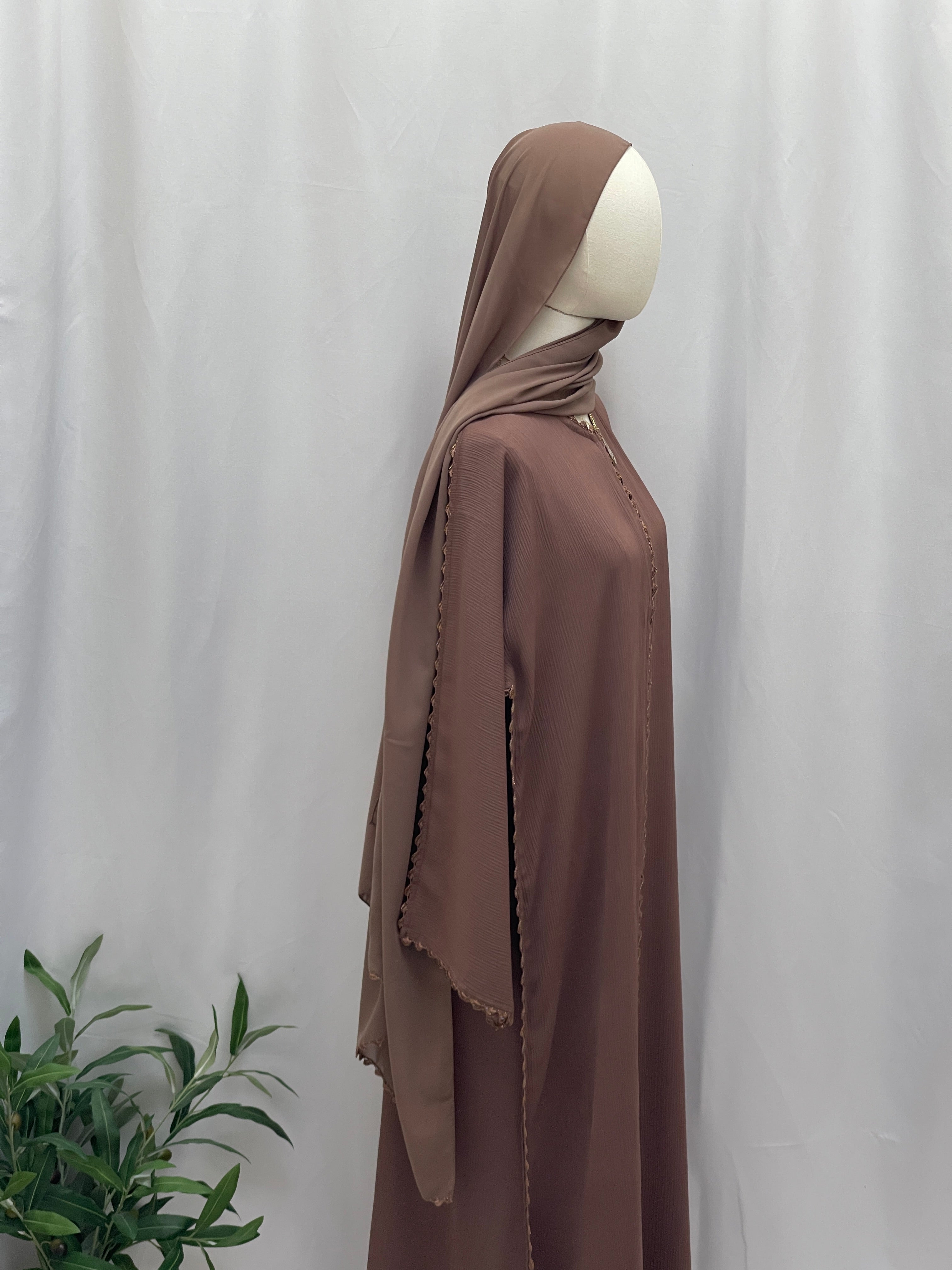 Palestinian Elegance Ghosoon Abaya in brown with long flowing sleeves and matching hijab on mannequin
