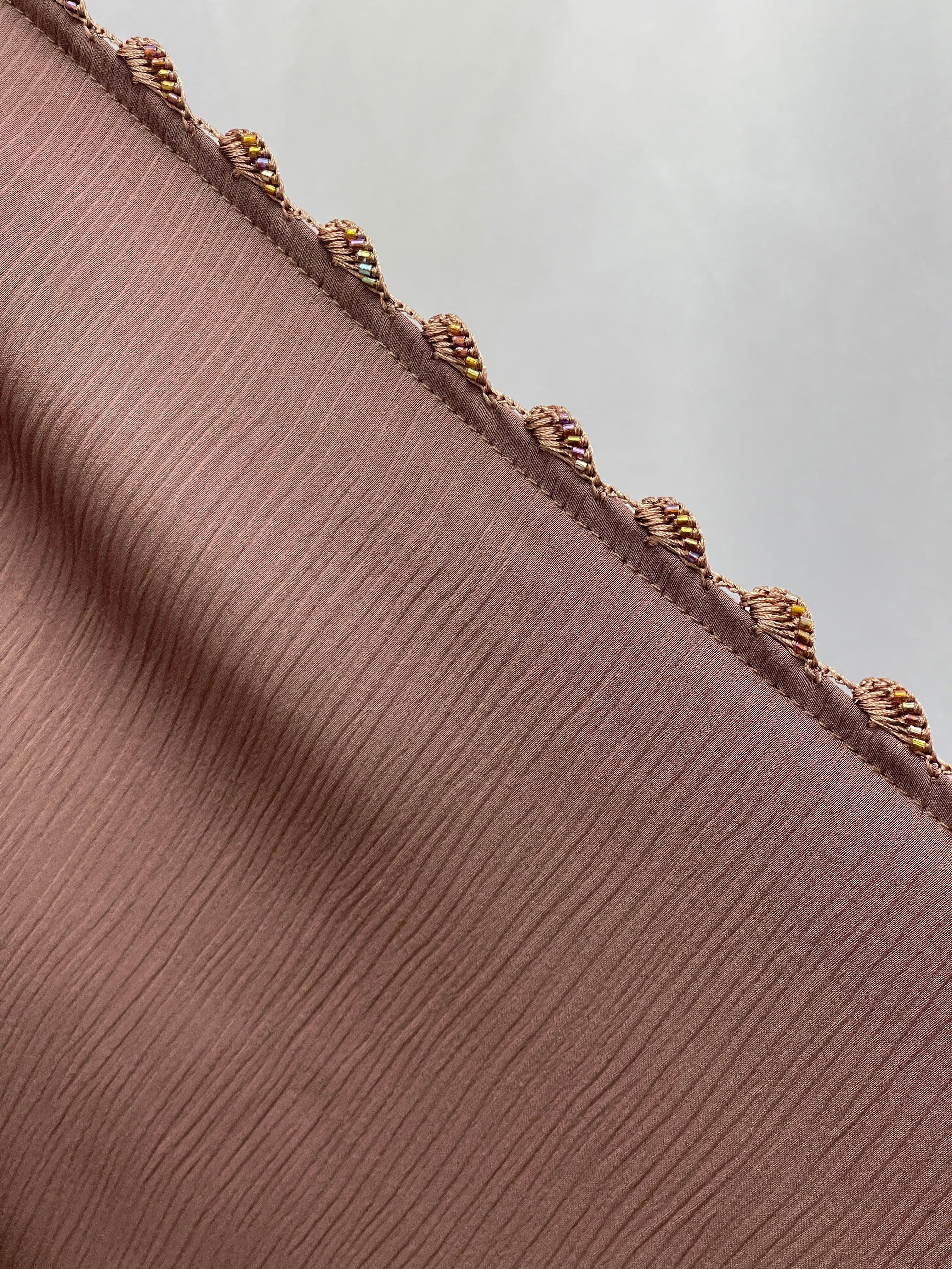Close-up of textured fabric detail with decorative trim on Palestinian Elegance Ghosoon Abaya