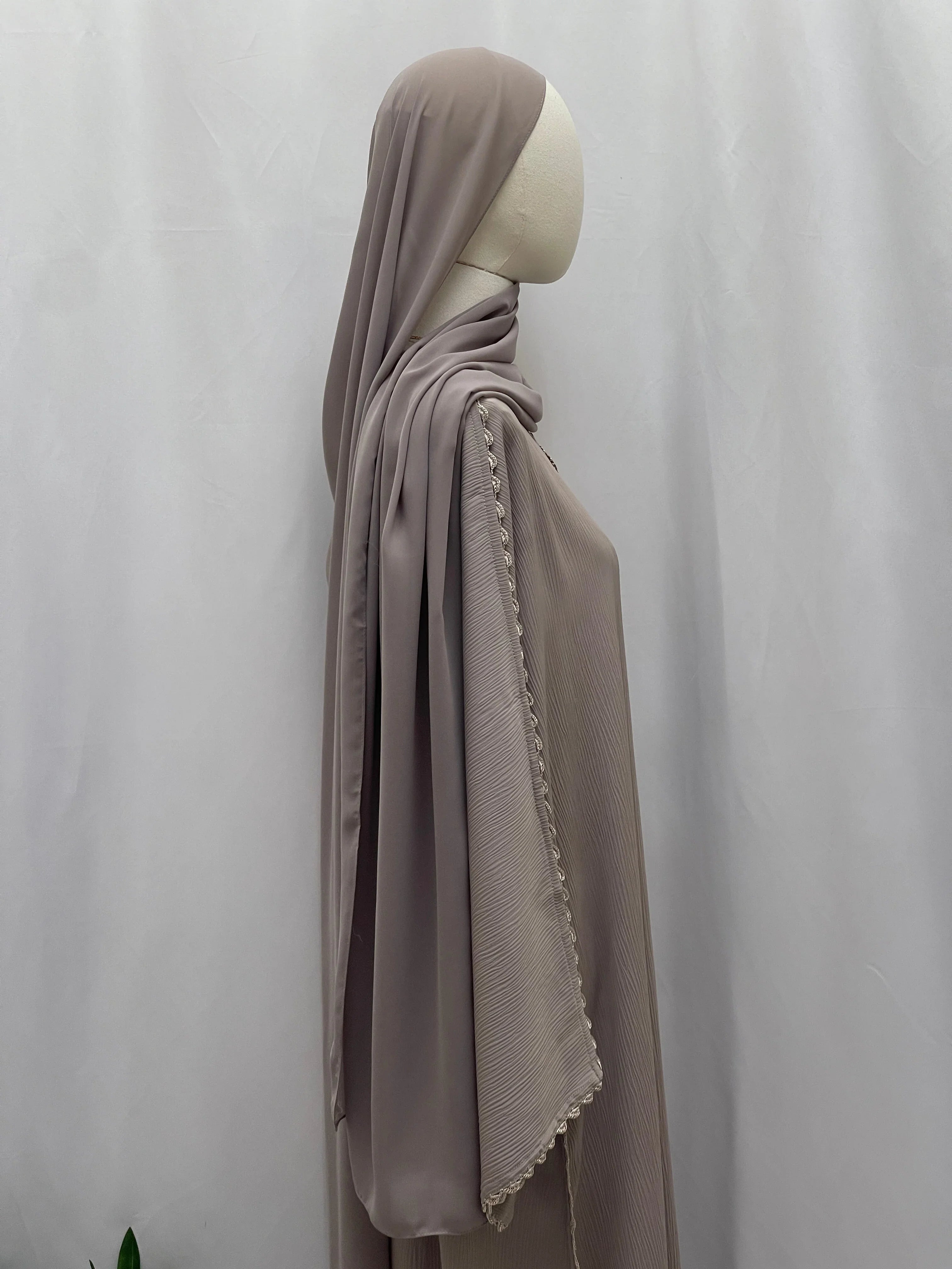 Palestinian Elegance Ghosoon Abaya in taupe with delicate lace trim on sleeve, displayed on mannequin