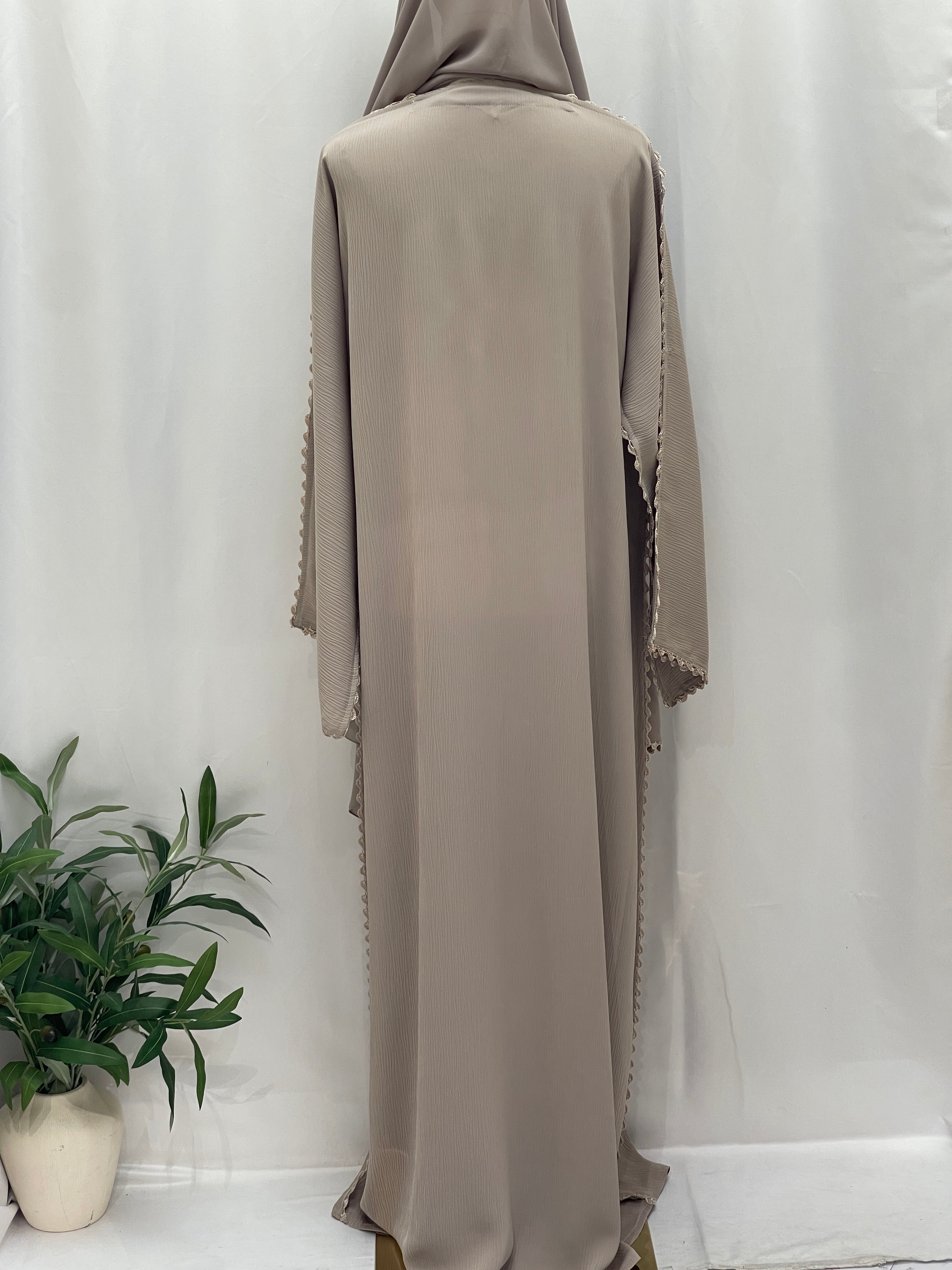 Back view of a beige Ghosoon Abaya by Palestinian Elegance with delicate edge detailing