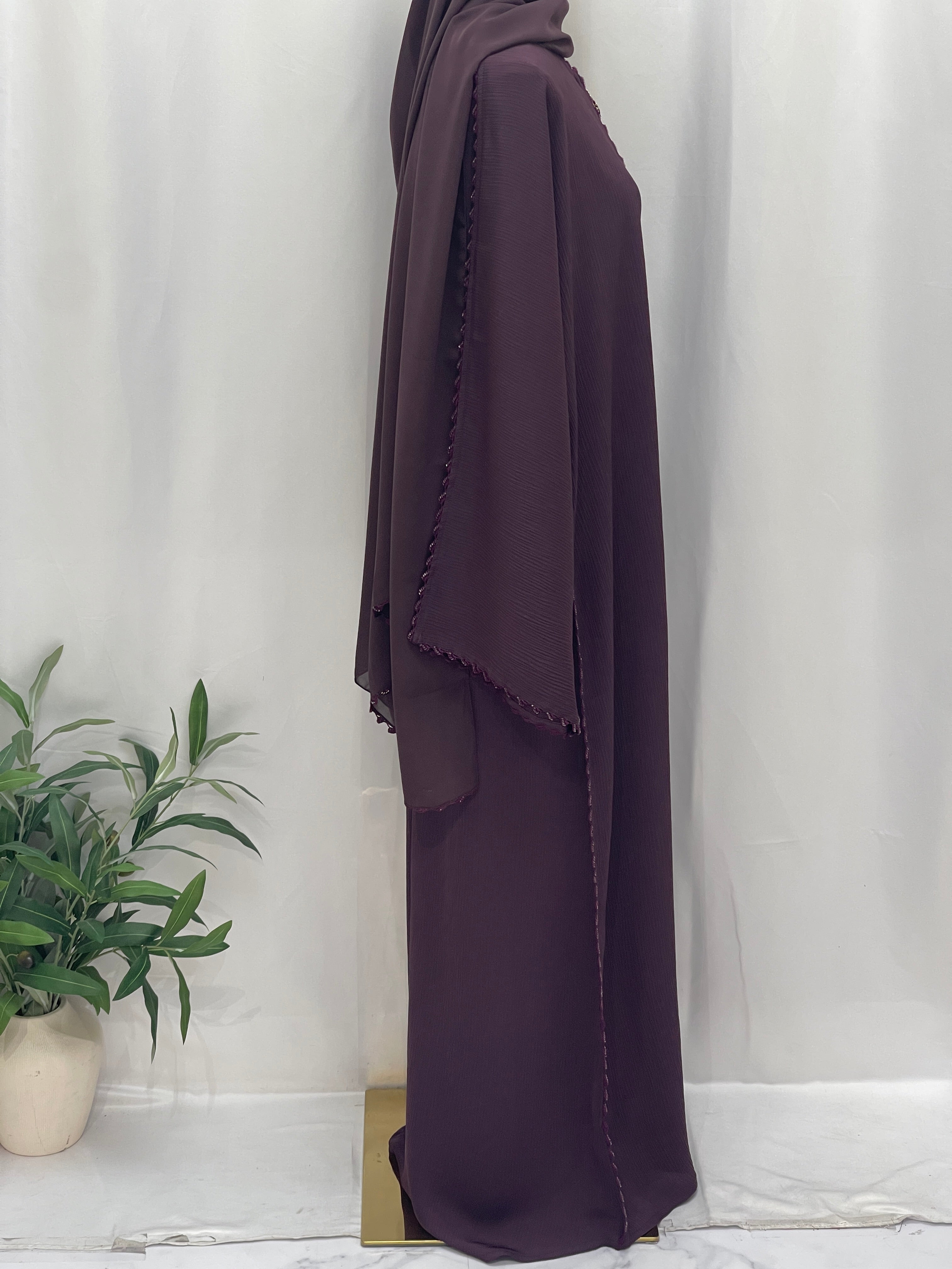 Palestinian Elegance Ghosoon Abaya in deep purple with detailed trim along sleeves and flowing fabric