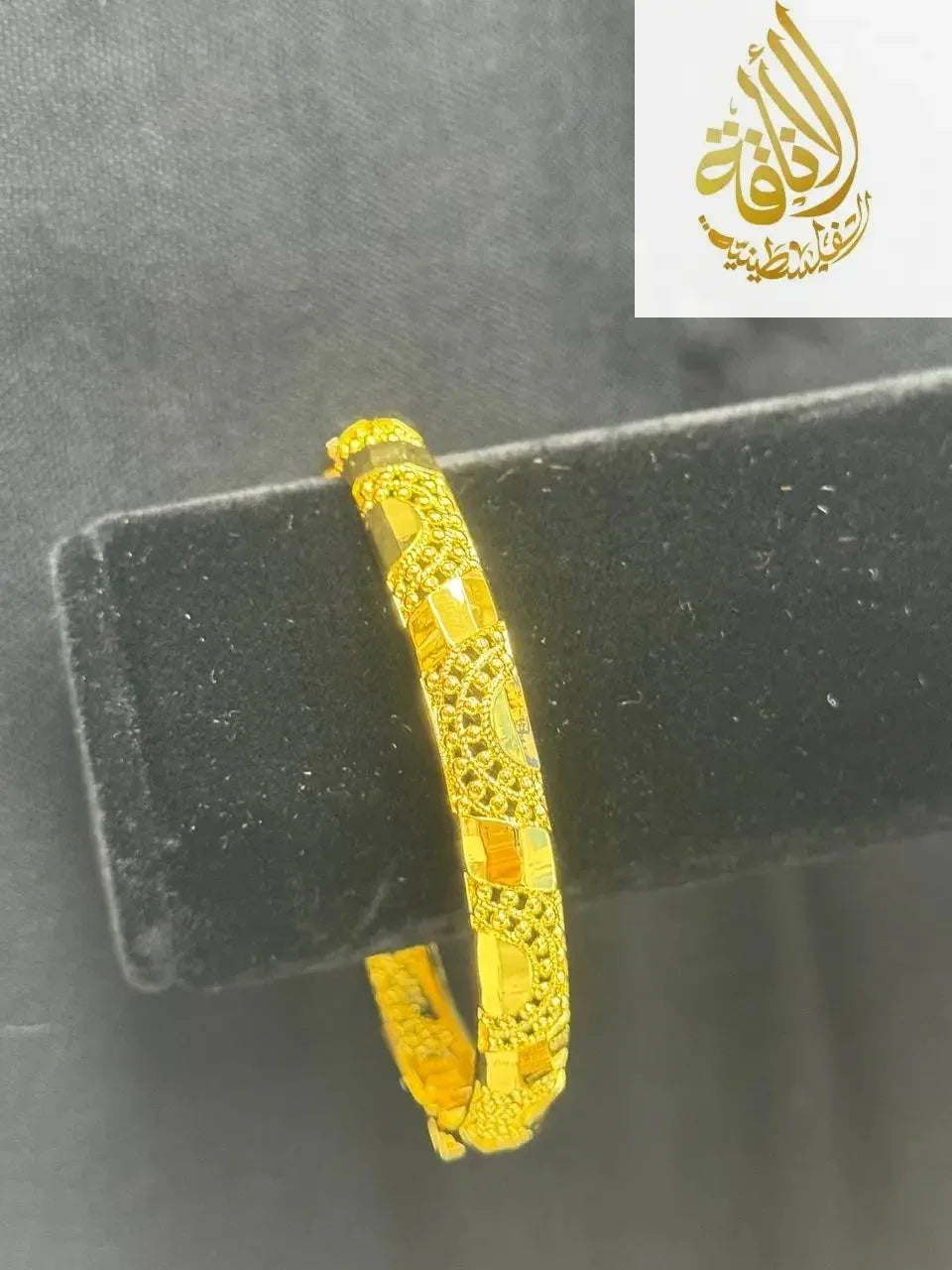 Palestinian Elegance imitated gold bangle bracelet for women with intricate design on black stand