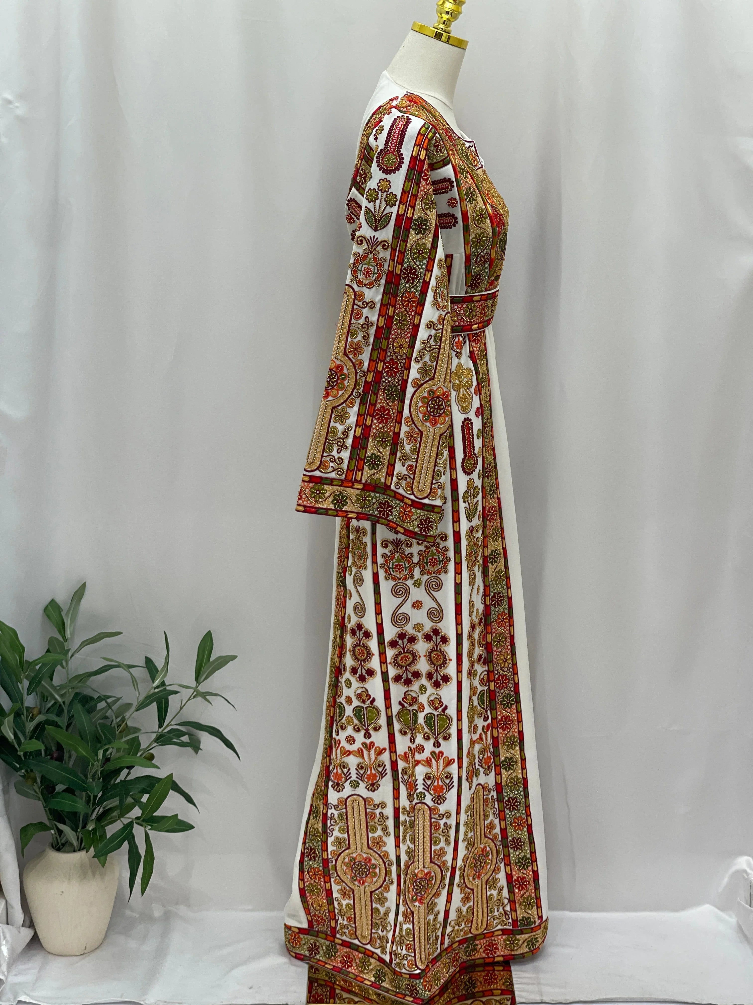 Golden Blossom Beaded Embroidered Thobe on mannequin side view white gown with red and gold floral embroidery and waist belt