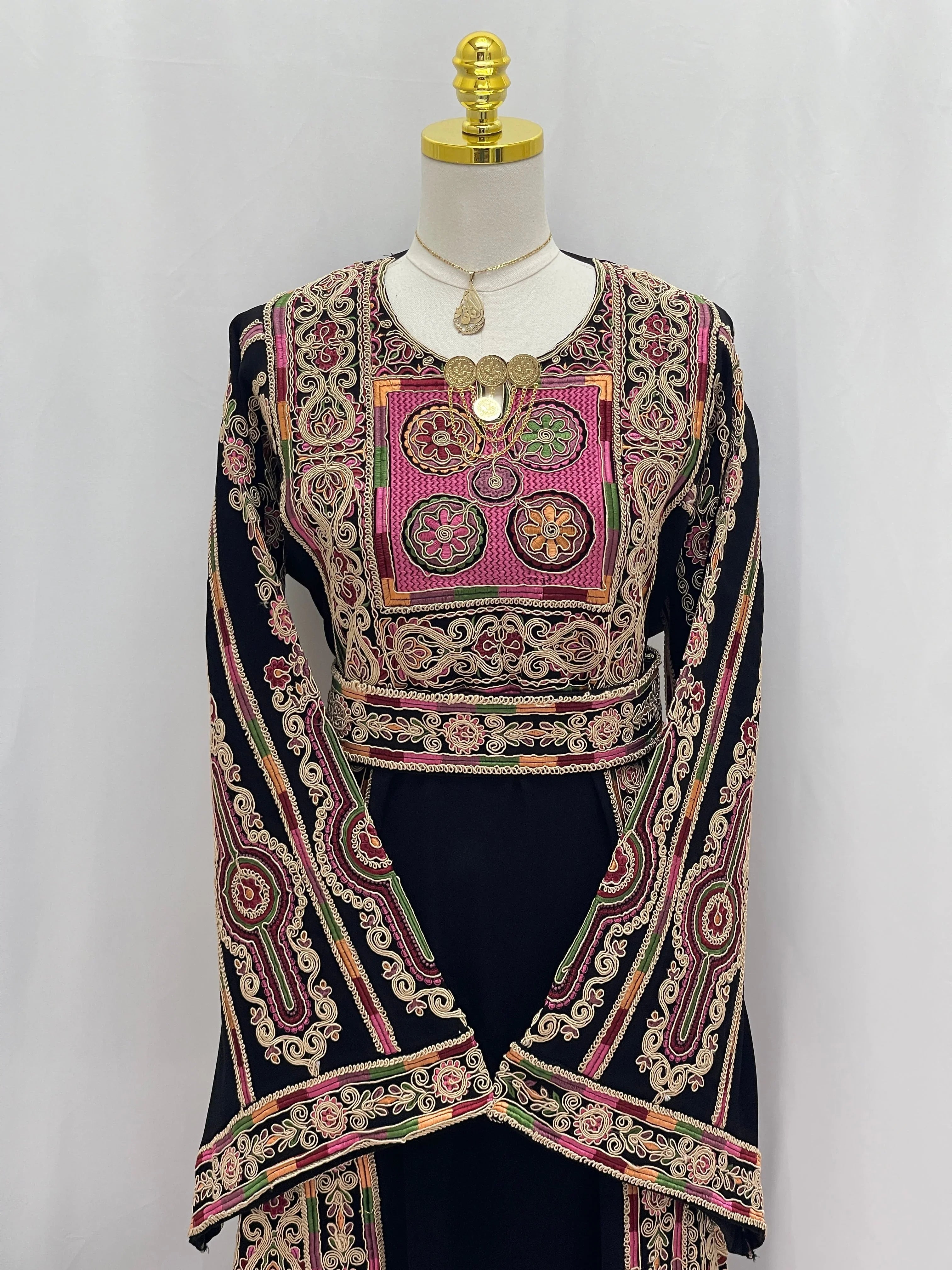 Palestinian Elegance Golden Thread Embroidered Thobe black with intricate pink and green chest panel and long sleeves