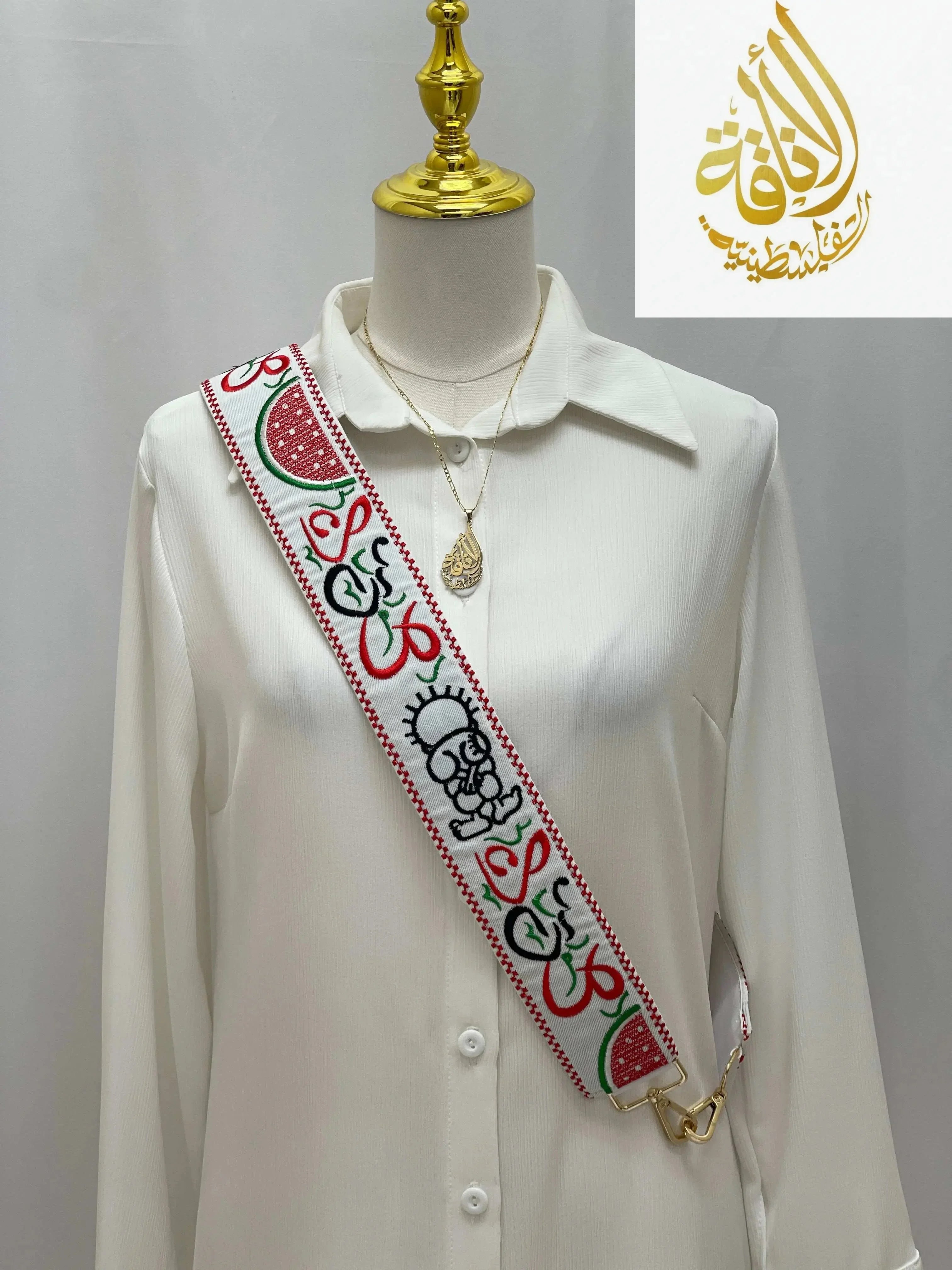 Palestinian embroidered purse strap with traditional colorful patterns worn over white shirt