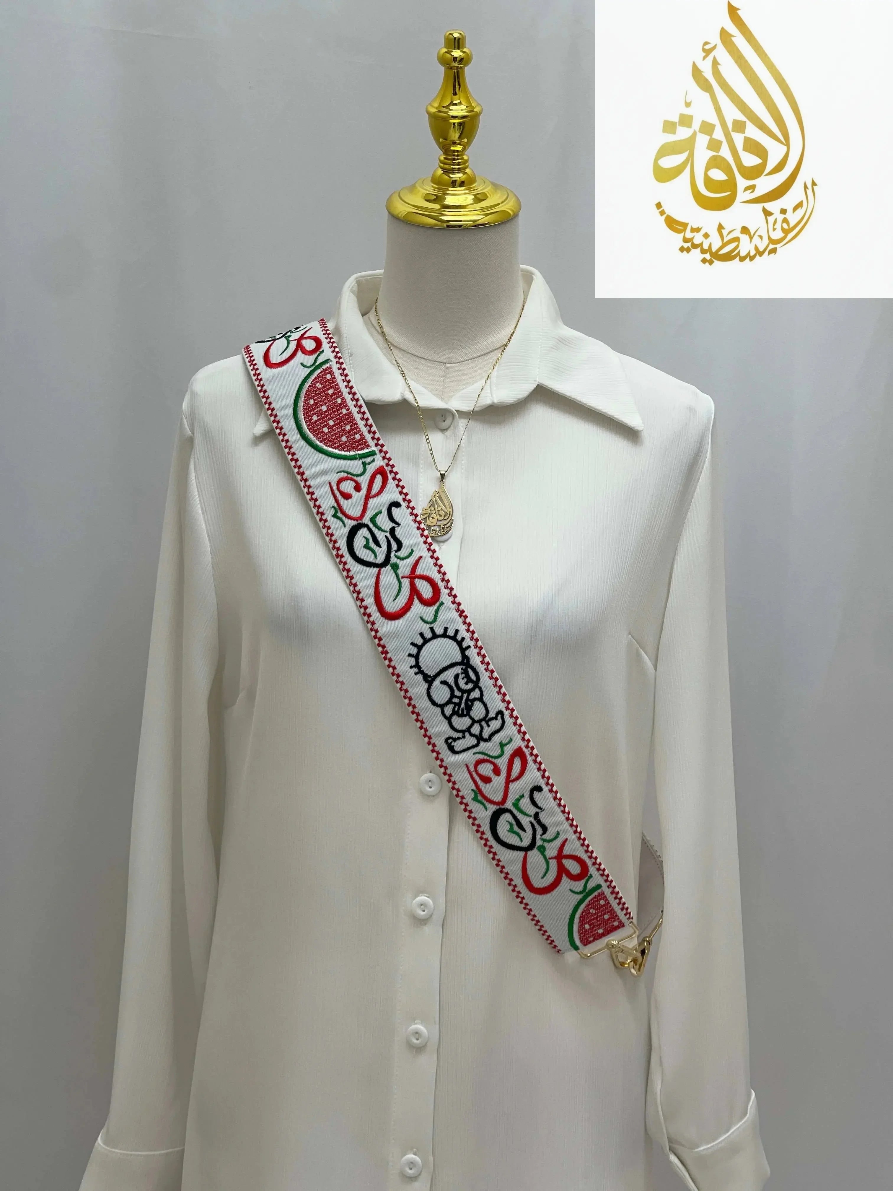 Palestinian Elegance white embroidered purse strap with colorful traditional patterns on a white blouse