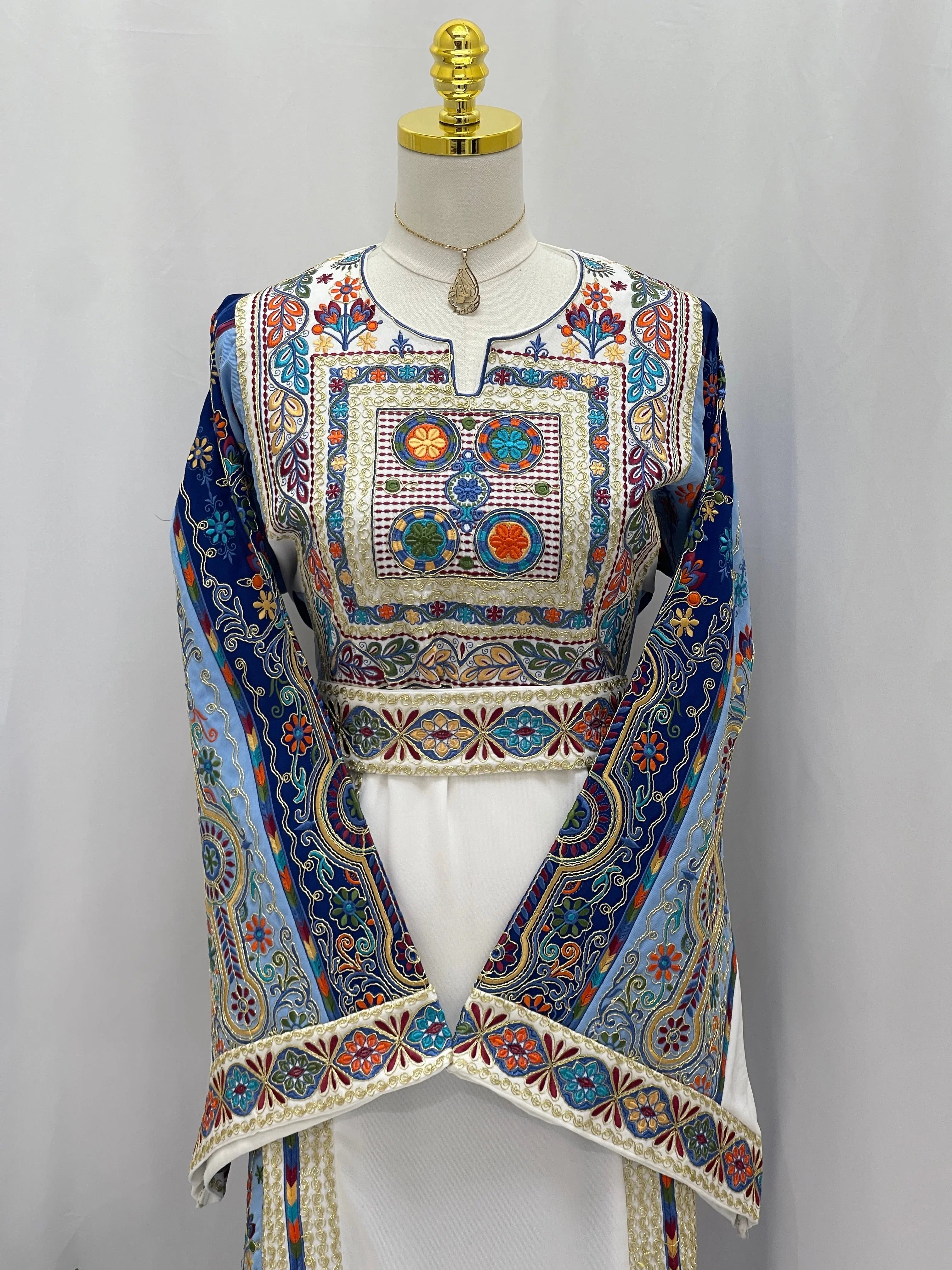 Heavenly Blossoms Thobe by Palestinian Elegance embroidered white thobe with colorful floral chest and blue embroidered sleeves