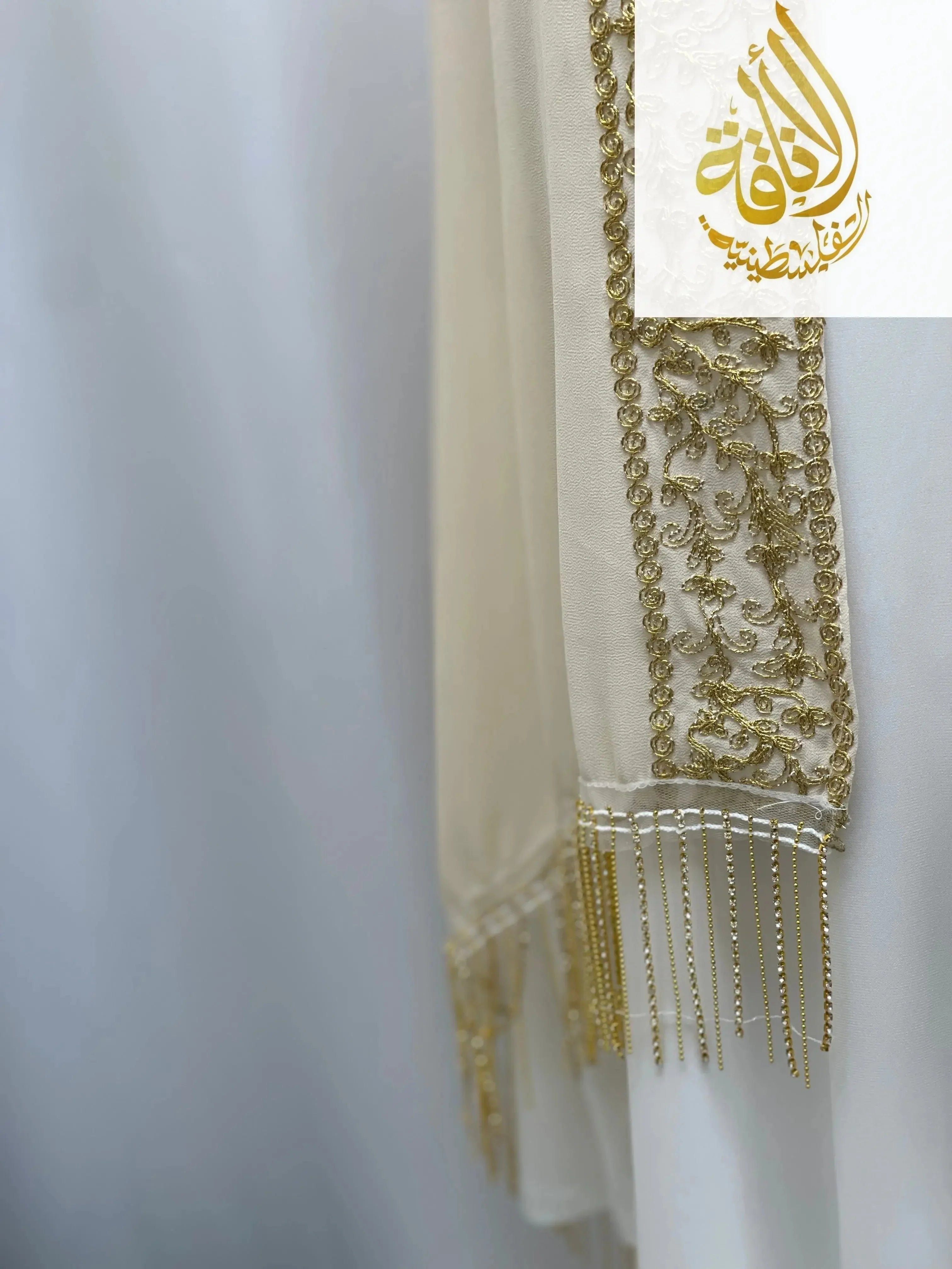 Close-up of Palestinian Traditional Modest Fashion Kasab Khirka embroidery with intricate gold thread and fringe details