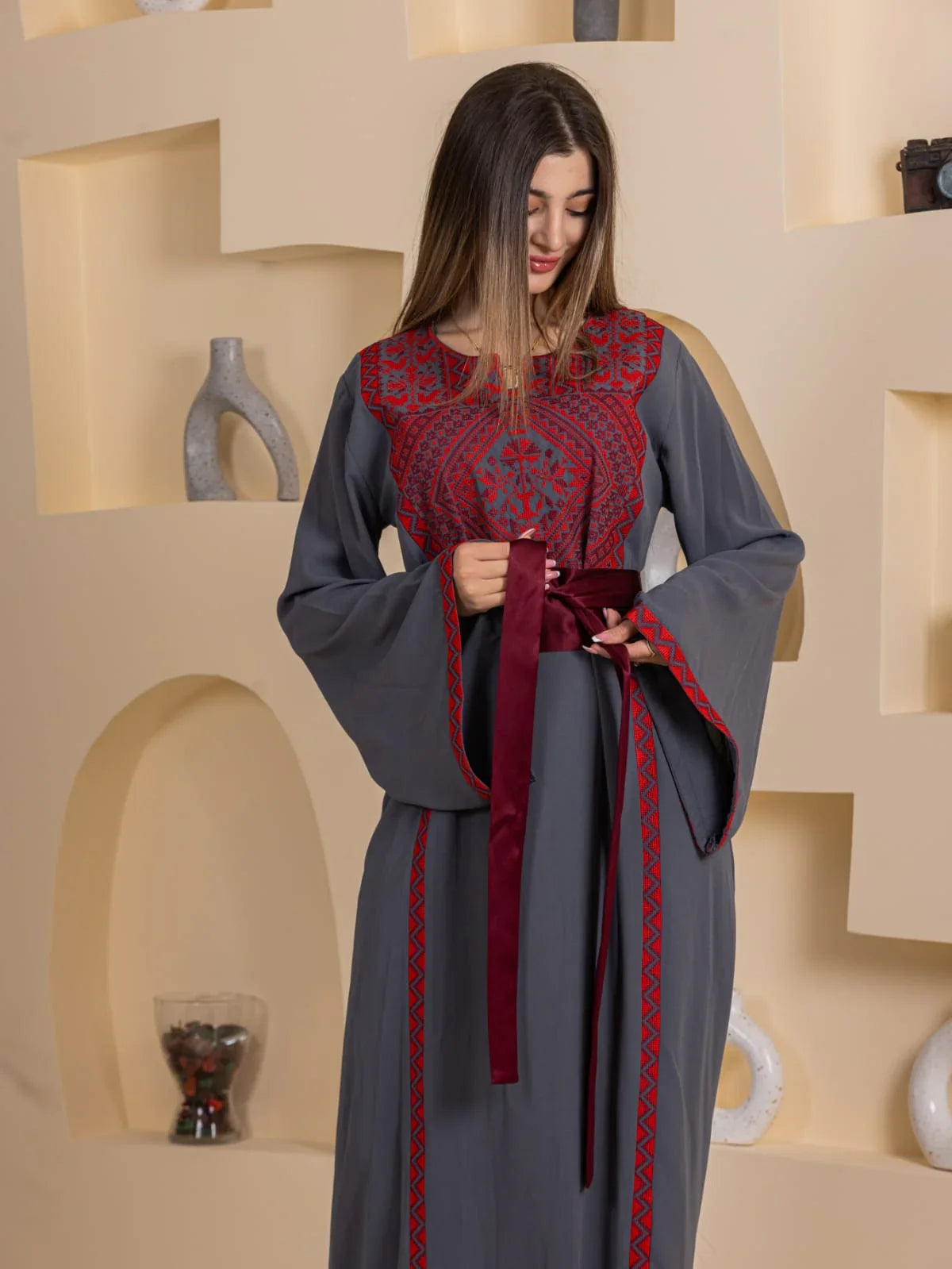 Huda Simply Embroidered Thoub. Grey embroidered Palestinian Elegance thobe with red detailing and burgundy sash