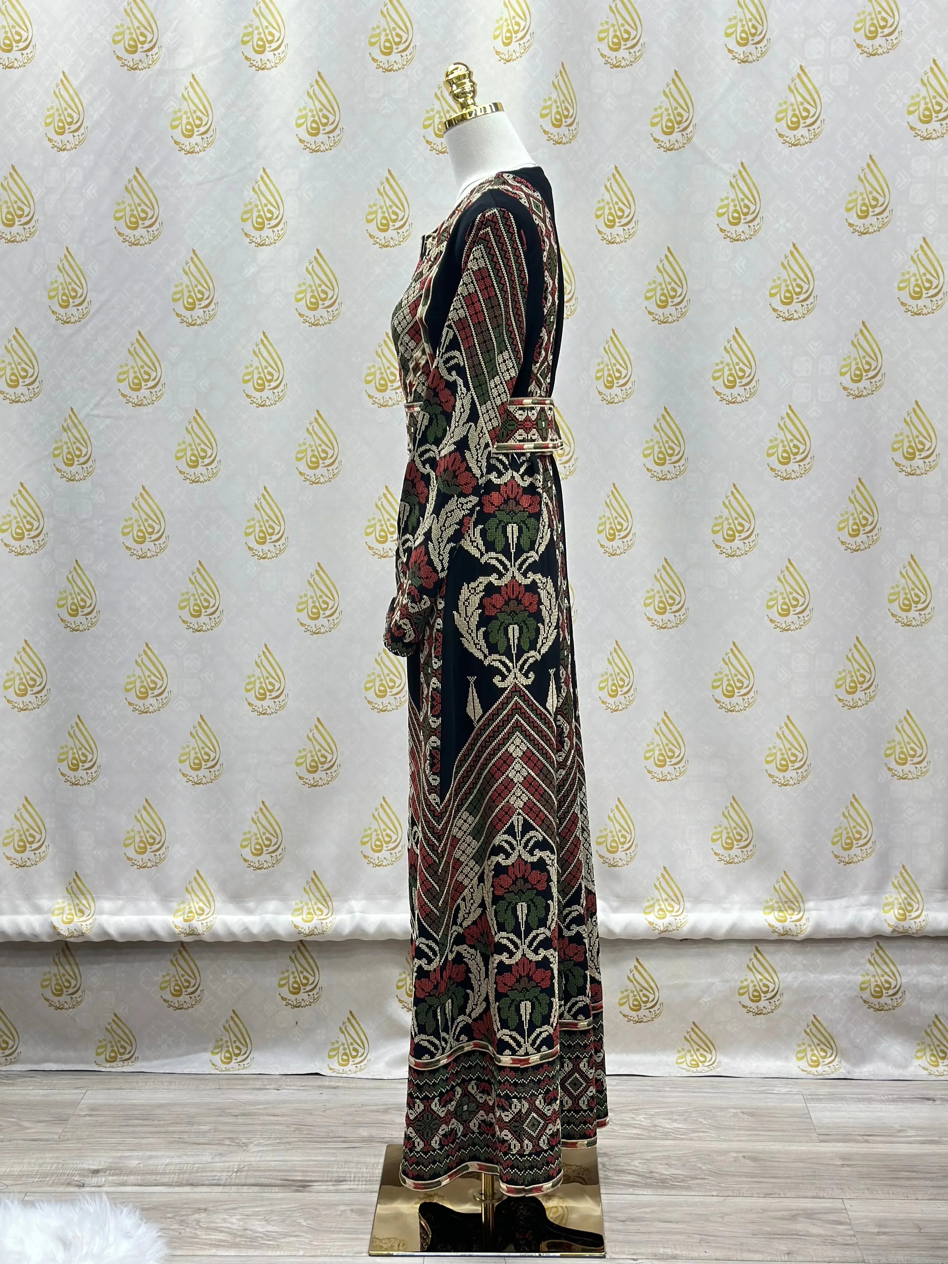 Side view of embroidered Palestinian thoub with intricate floral and geometric patterns on a mannequin