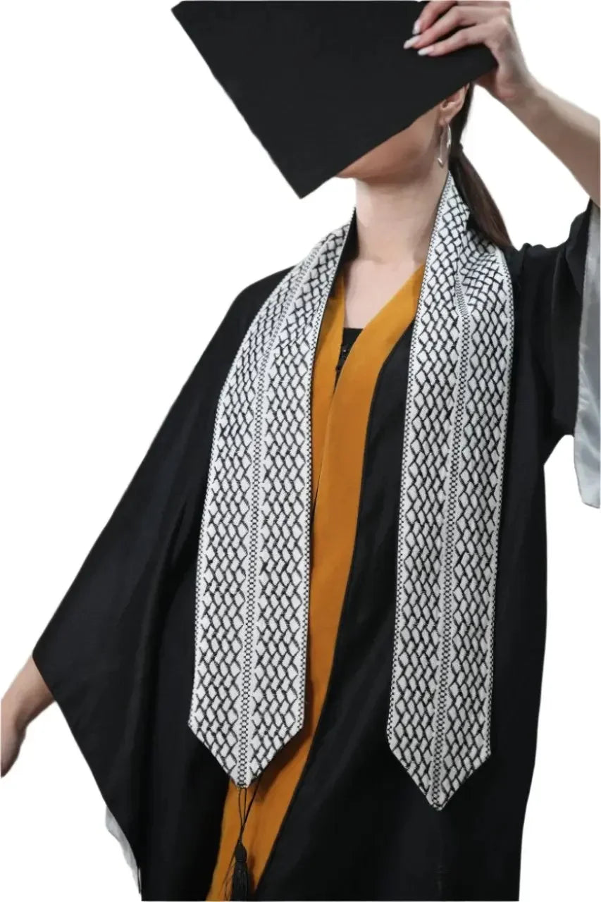 Palestinian keffiyeh graduation stole worn over black and gold graduation gown and cap