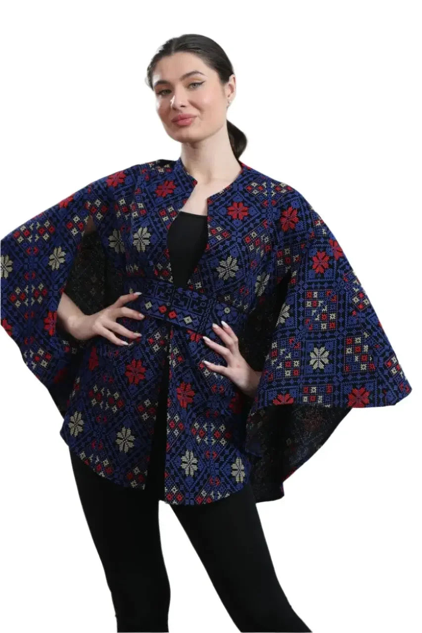 Palestinian tattreez cape with traditional embroidery in blue, red, and white colors worn by a woman