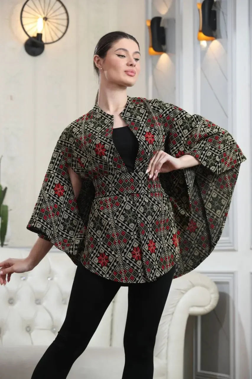 Woman wearing Palestinian tattreez cape by Palestinian Elegance with traditional red and black embroidery