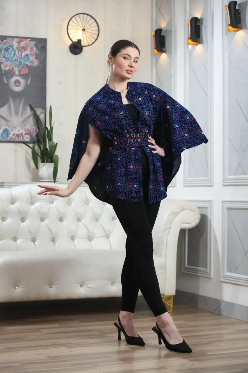 Woman wearing a Palestinian embroidered cape by Palestinian Elegance styled with black leggings and heels