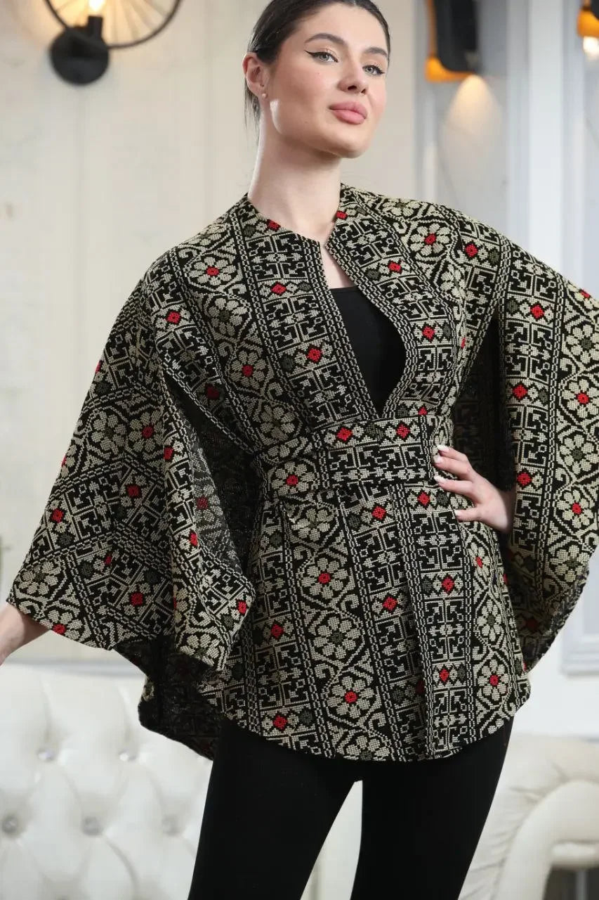 Palestinian embroidered cape by Palestinian Elegance worn over black outfit, featuring traditional intricate embroidery