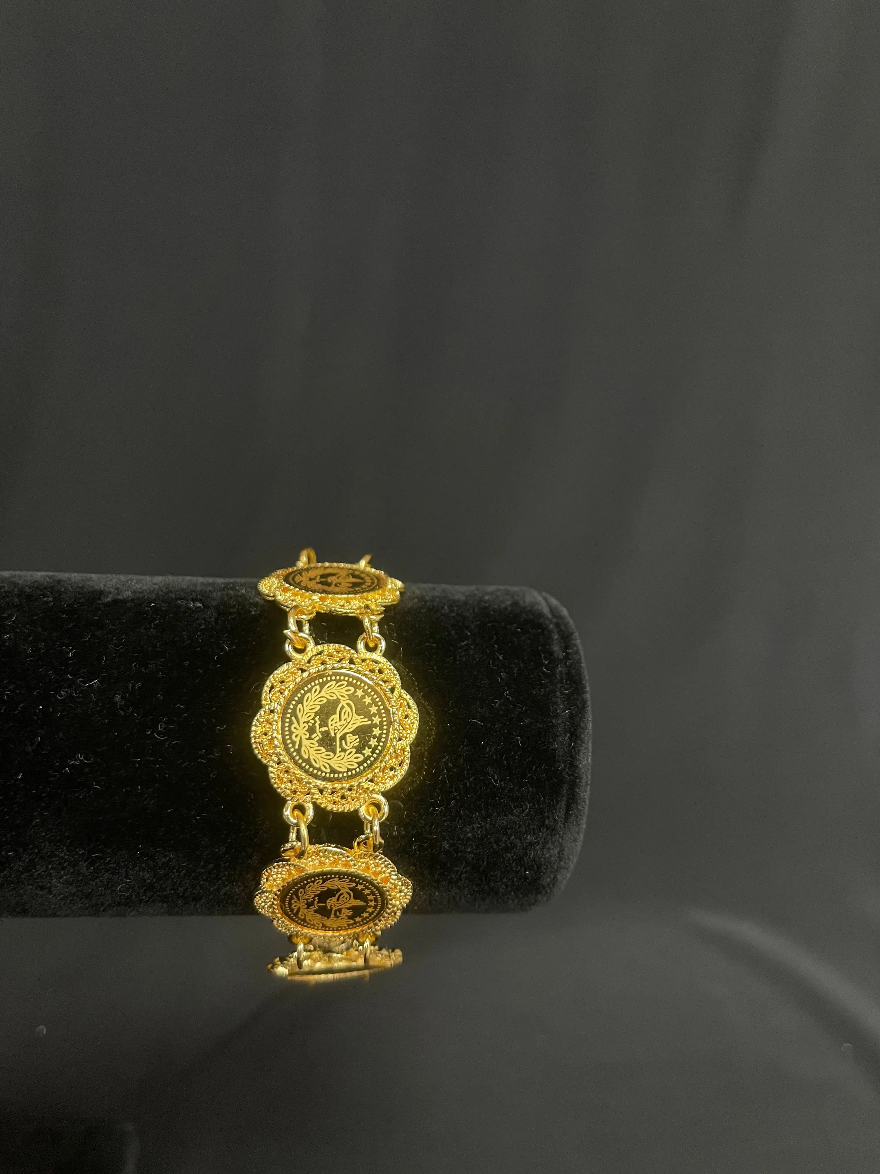 Palestinian Elegance imitated gold bracelet for women with intricate circular designs on a black display