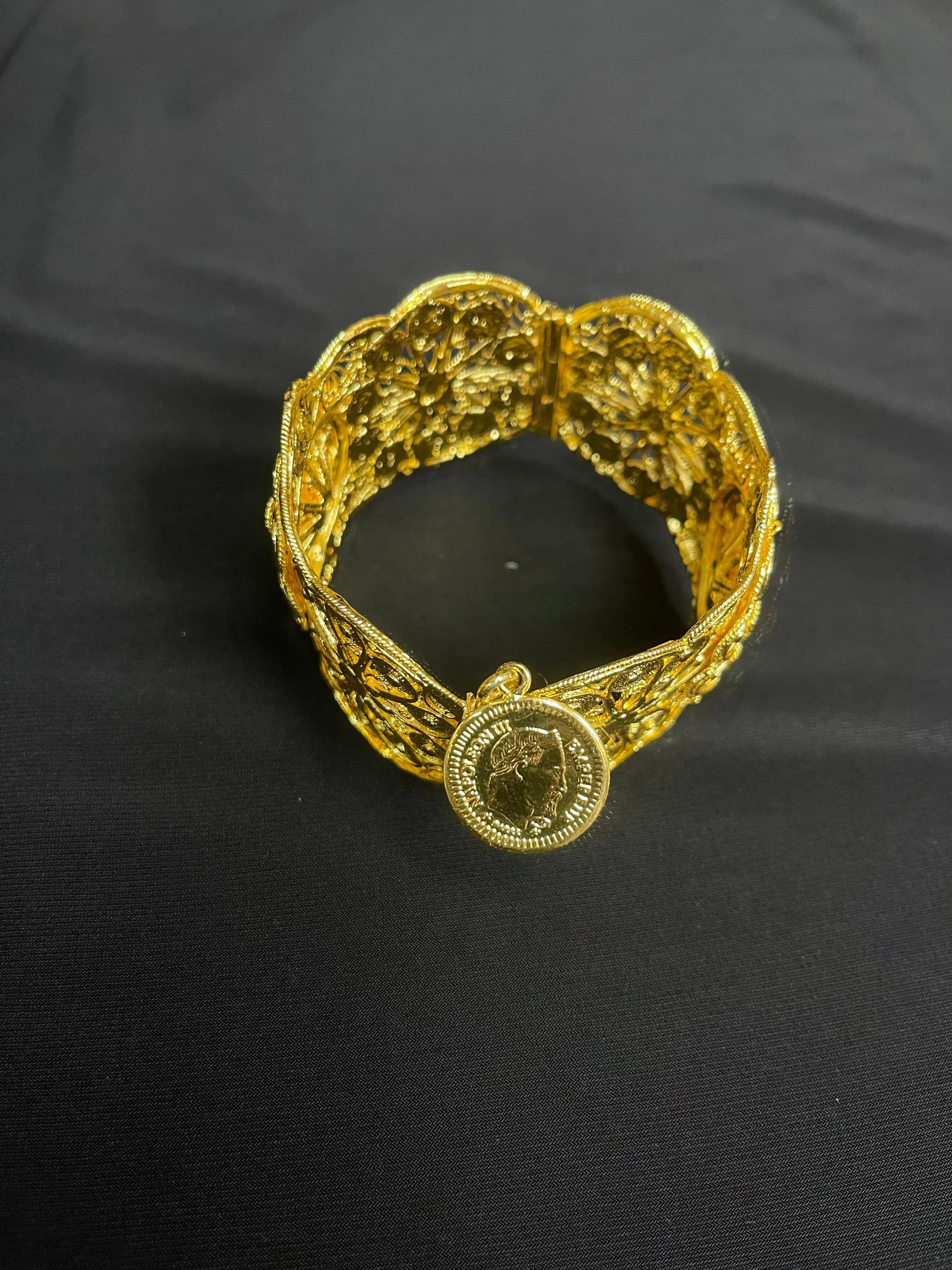 Palestinian Elegance imitated gold bracelet with intricate floral patterns and coin charm