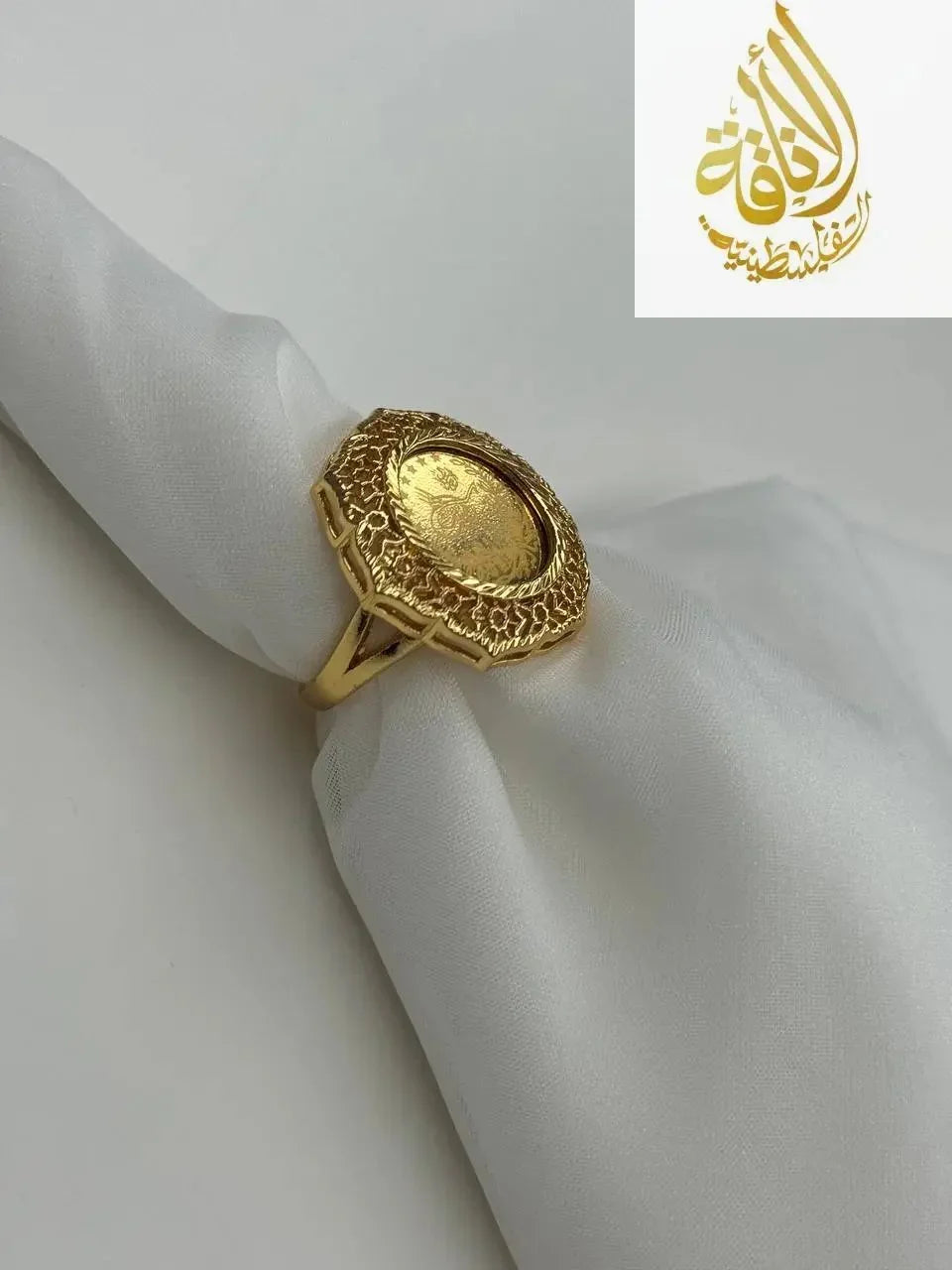 Palestinian Elegance falahi ring gold plated with intricate textured design on white fabric