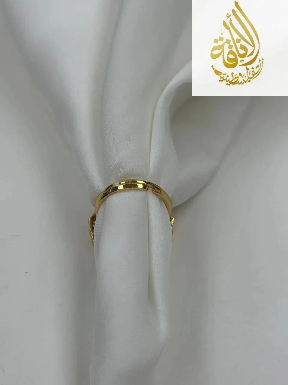 Palestinian Elegance falahi ring gold plated displayed on white fabric showcasing its shiny imitated gold finish