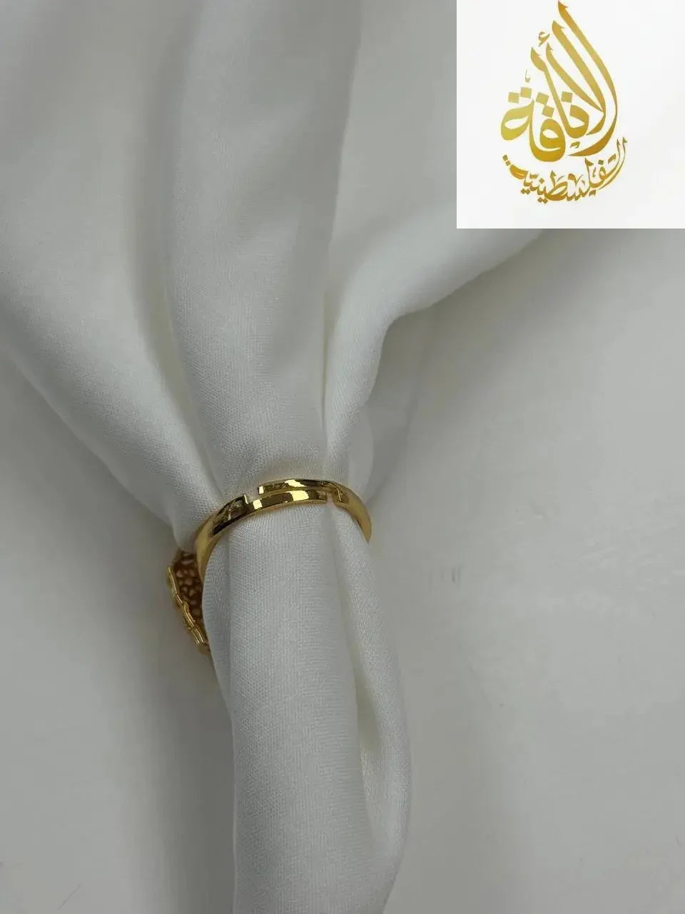 Palestinian Elegance falahi ring gold plated on white fabric showcasing imitated gold jewelry