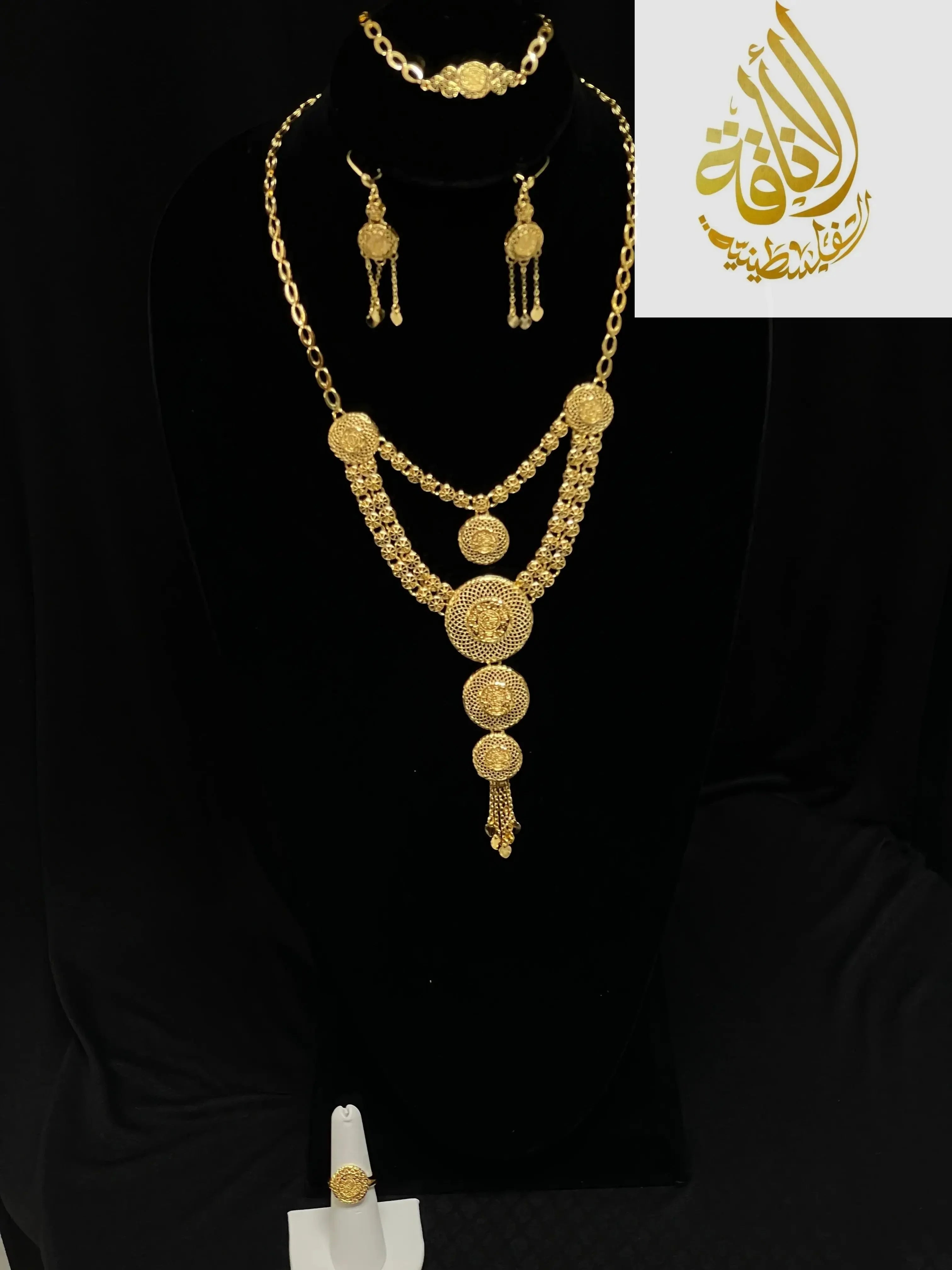 Palestinian Elegance gold layered necklace set with intricate circular pendants and matching earrings on black display