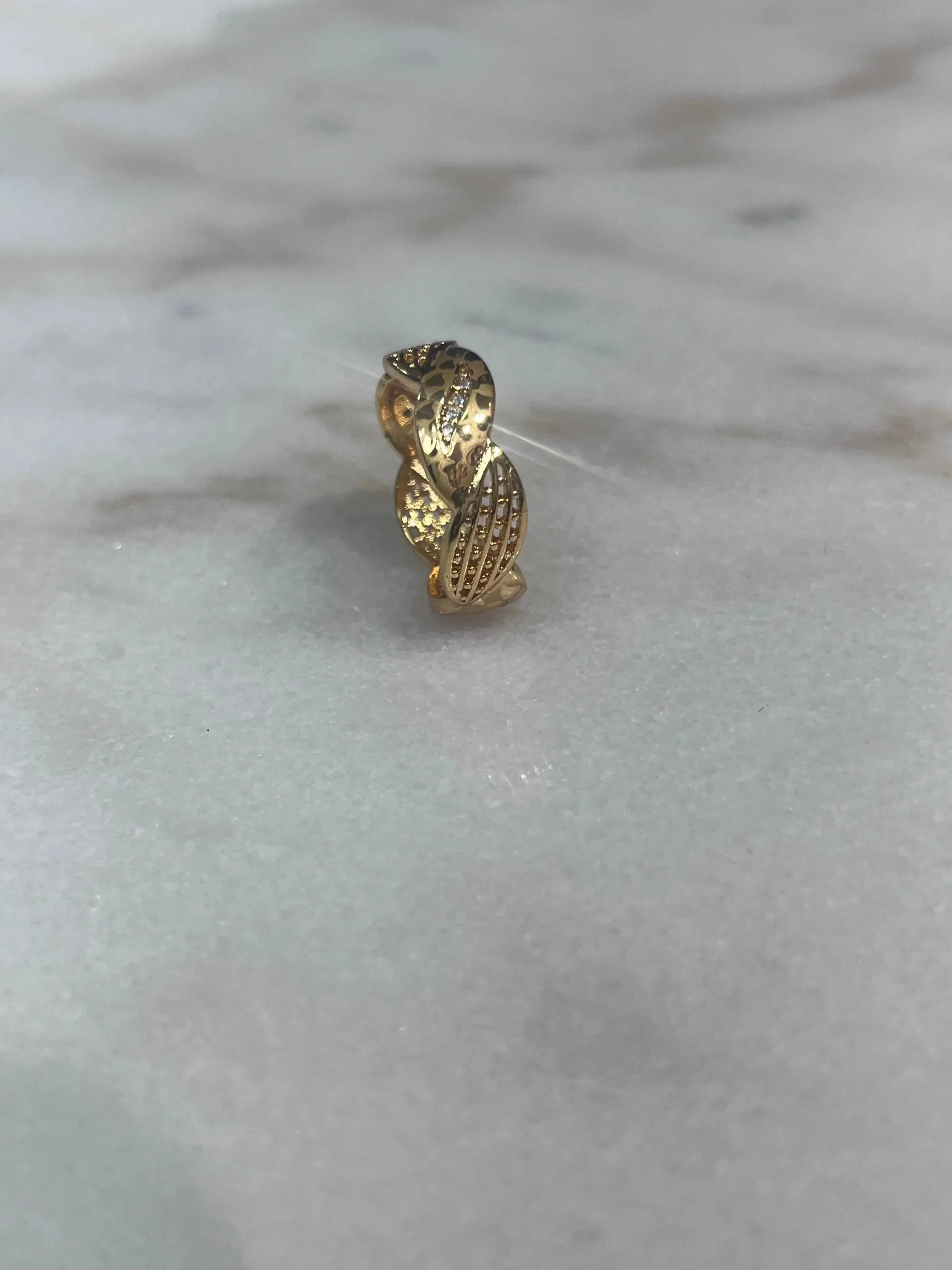 Palestinian Elegance imitation gold heart ring with intricate textured design on a marble surface