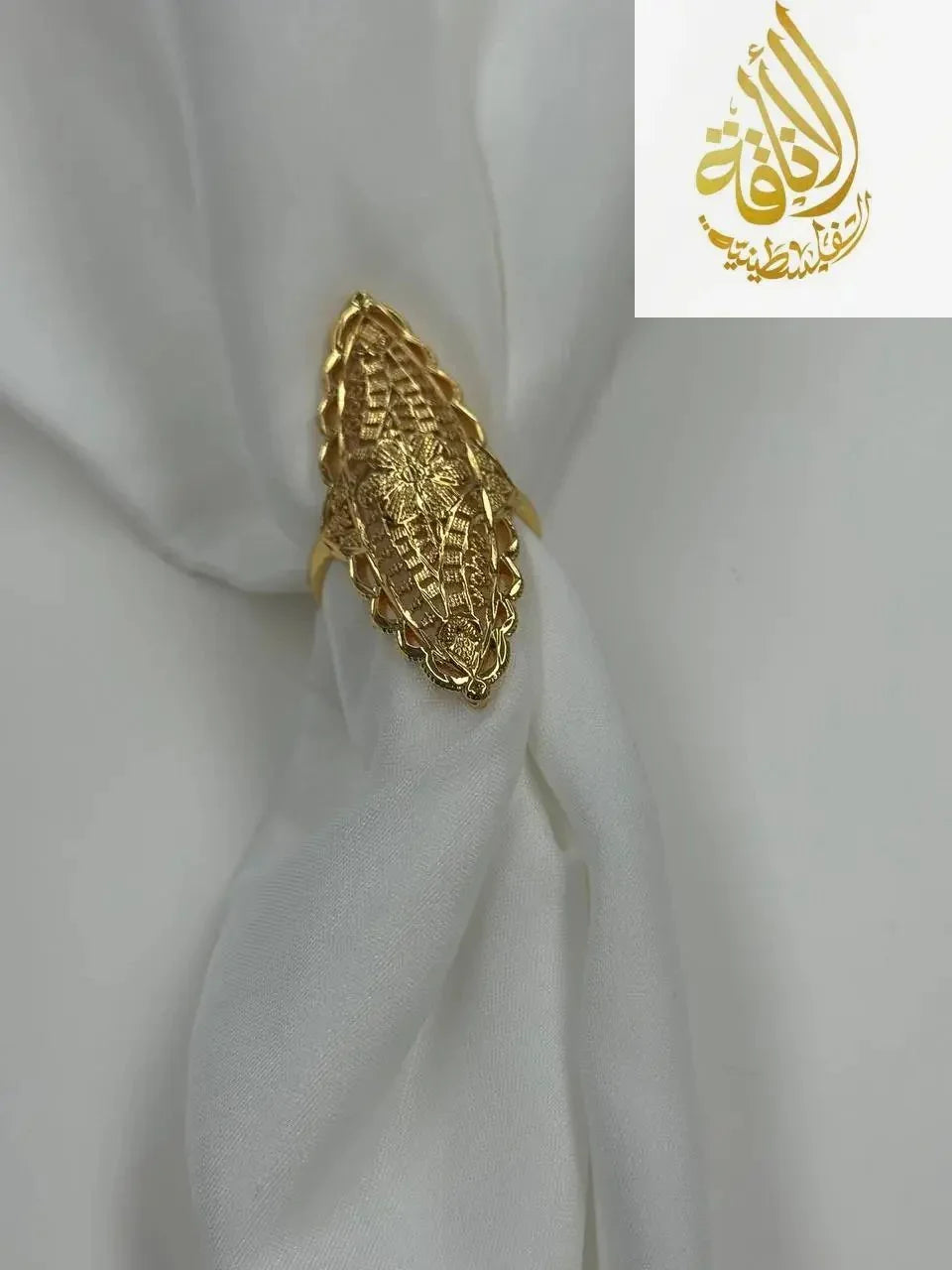 Imitated gold unique flower ring design by Palestinian Elegance on white fabric