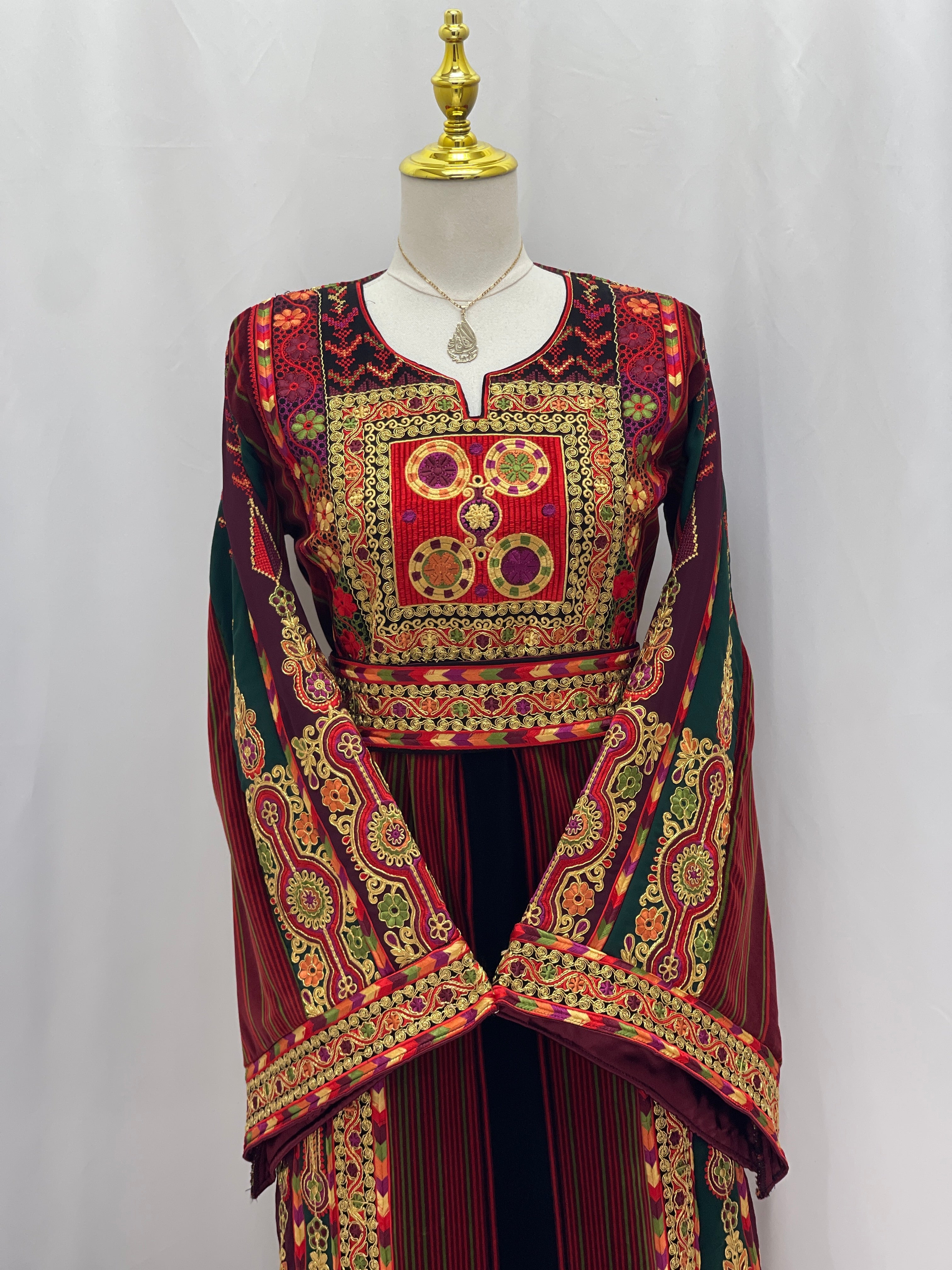 Palestinian Velvet Malaka Embroidered Thobe with intricate gold and red embroidery on mannequin