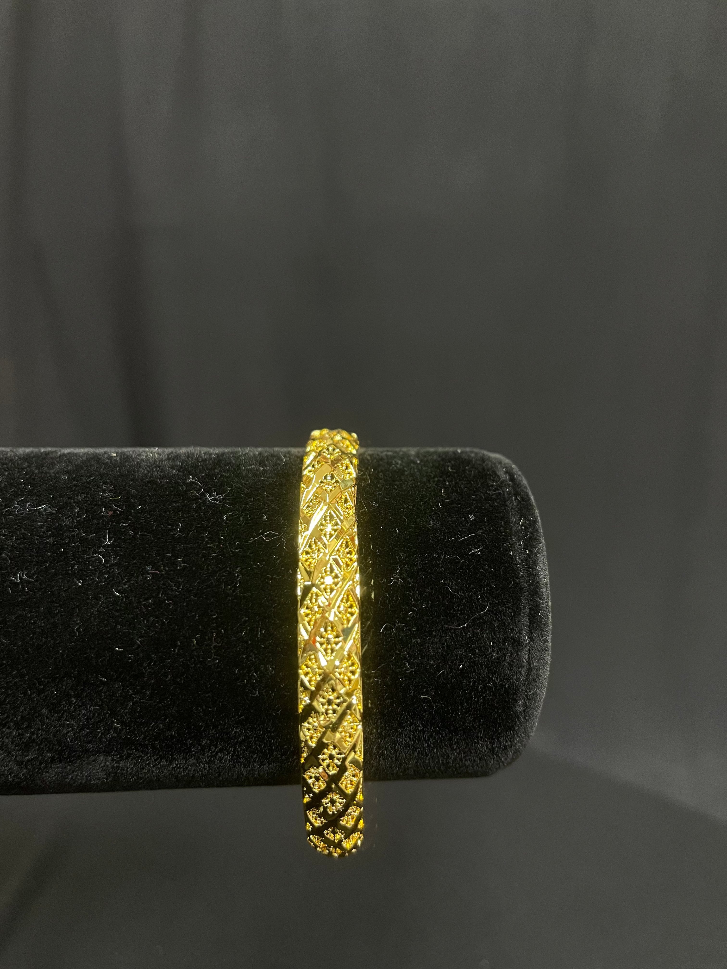 Palestinian Elegance imitated gold Palestinian gold bangle bracelet with intricate detailing on black display