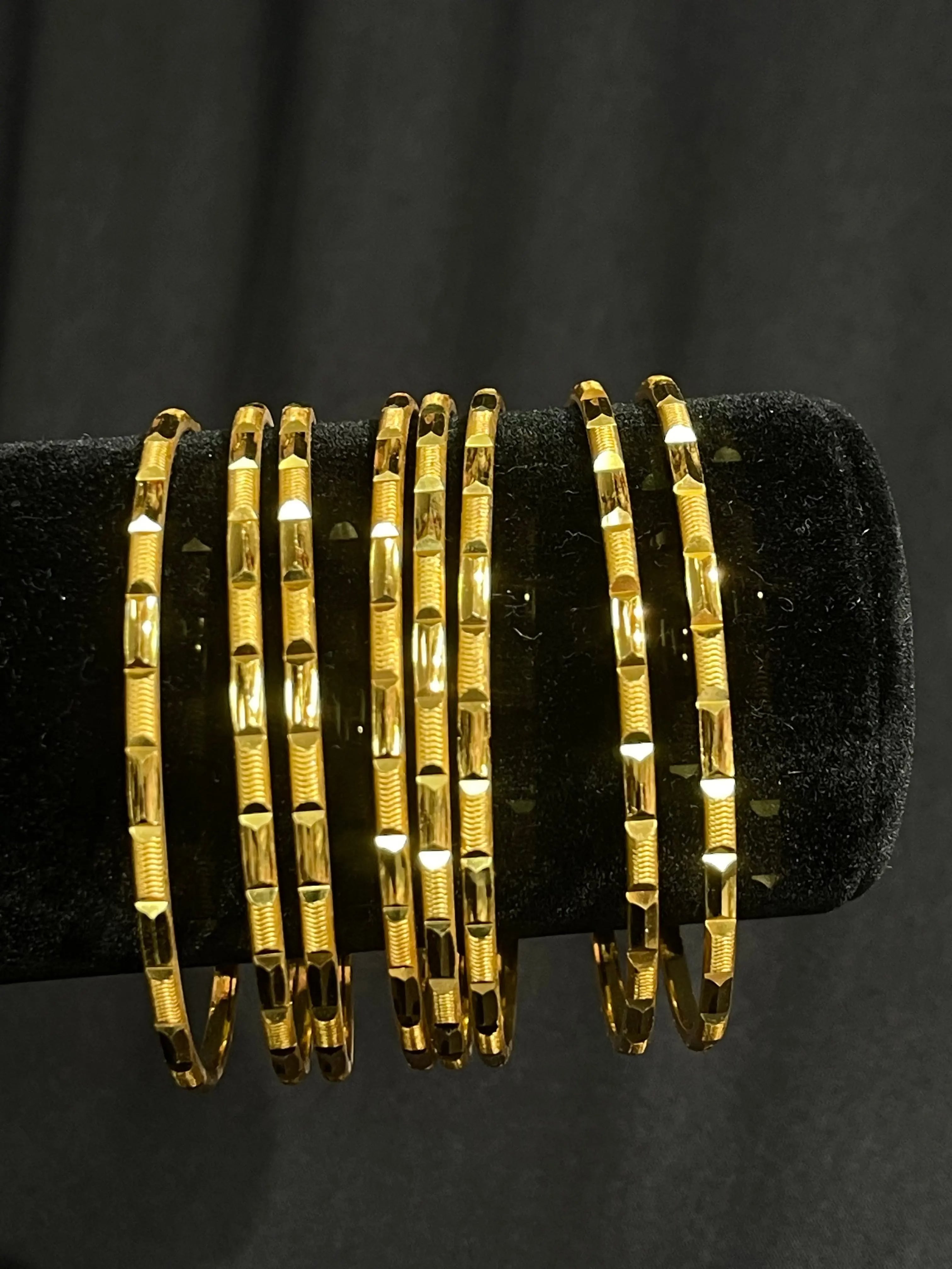 Palestinian Elegance imitated gold Karmela Thin Bangles set with textured design on black display