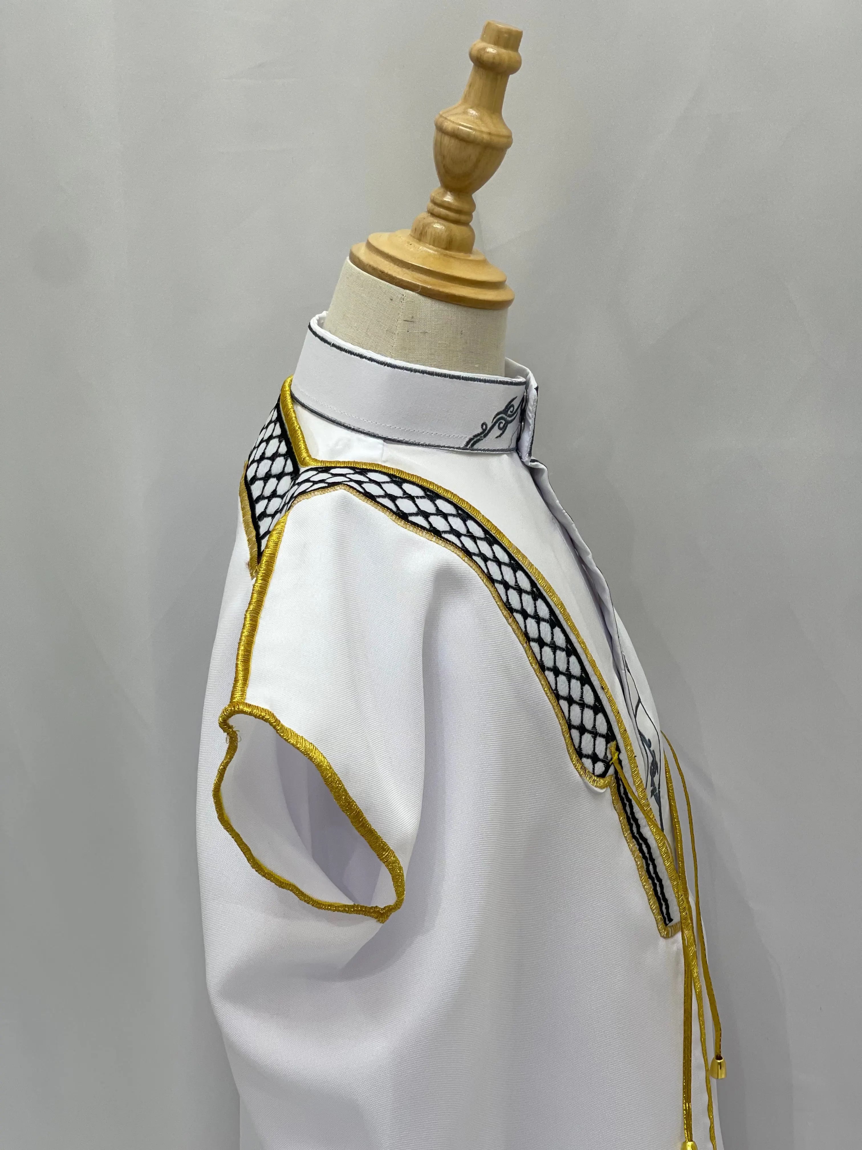 White Kids Kuffiyeh Bisht with black and gold embroidery on mannequin by Palestinian Elegance