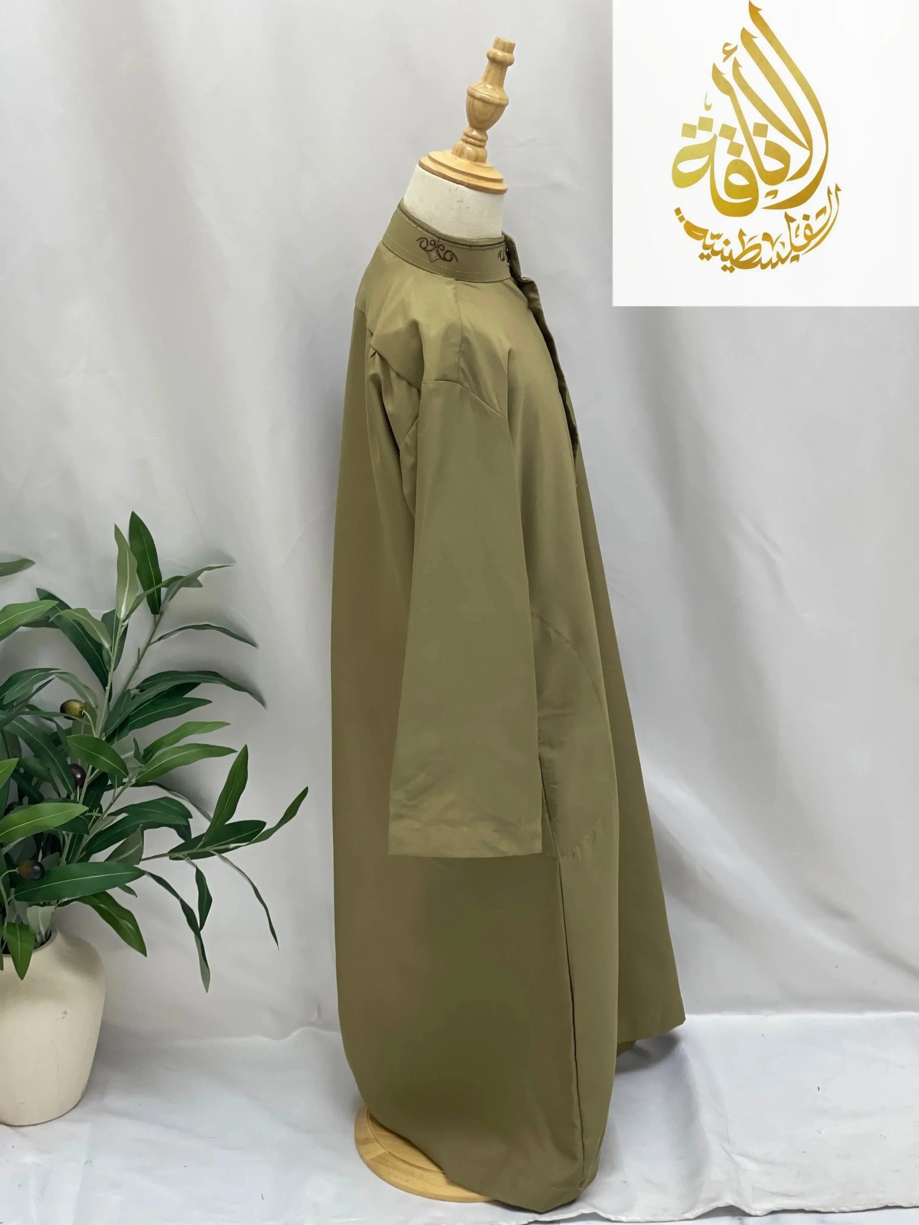 Palestinian Elegance kids embroidered thobe in olive green displayed on a mannequin with intricate collar embroidery
