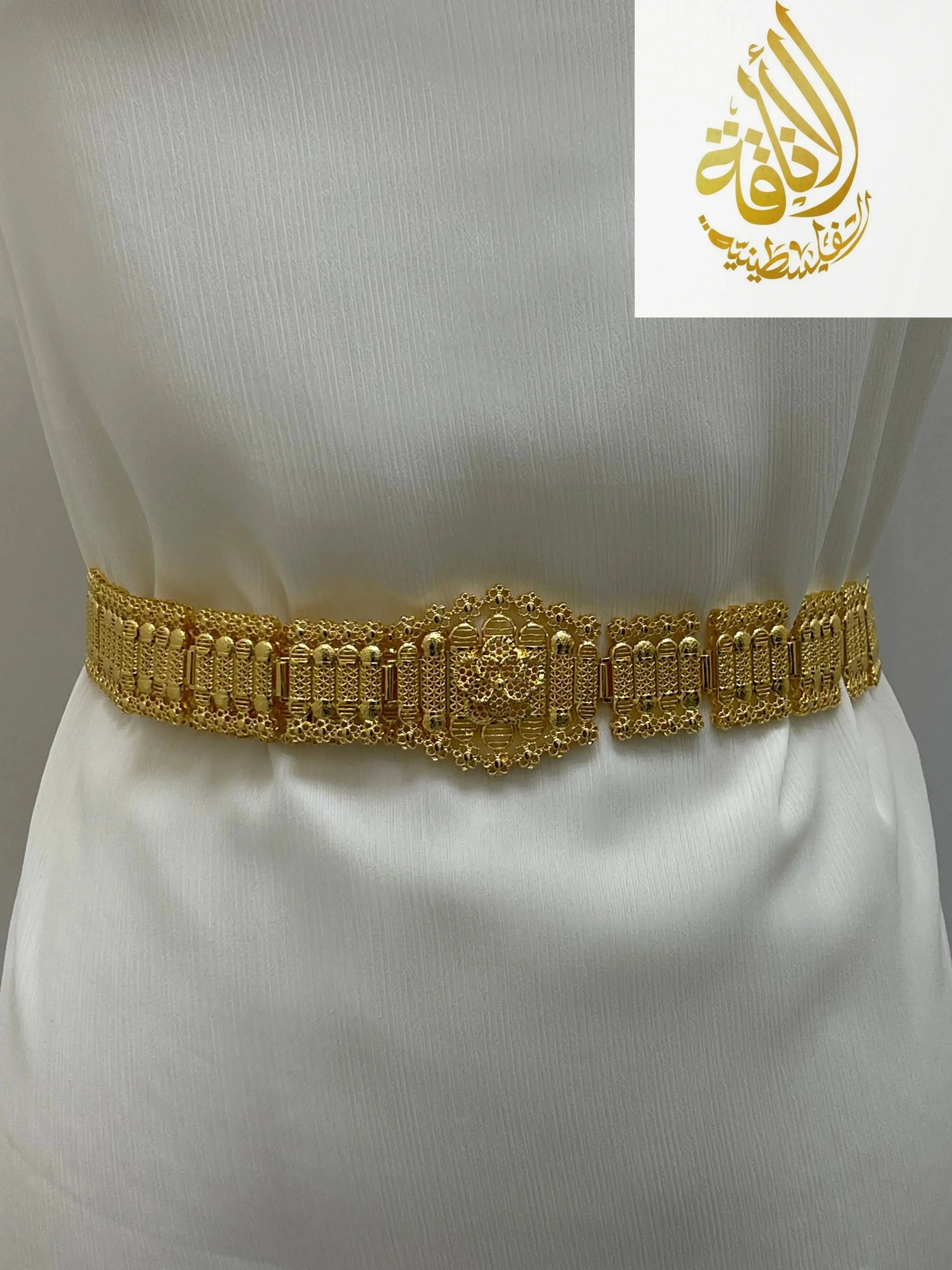 Kurdish gold style belt with intricate designs worn on white fabric from Palestinian Elegance