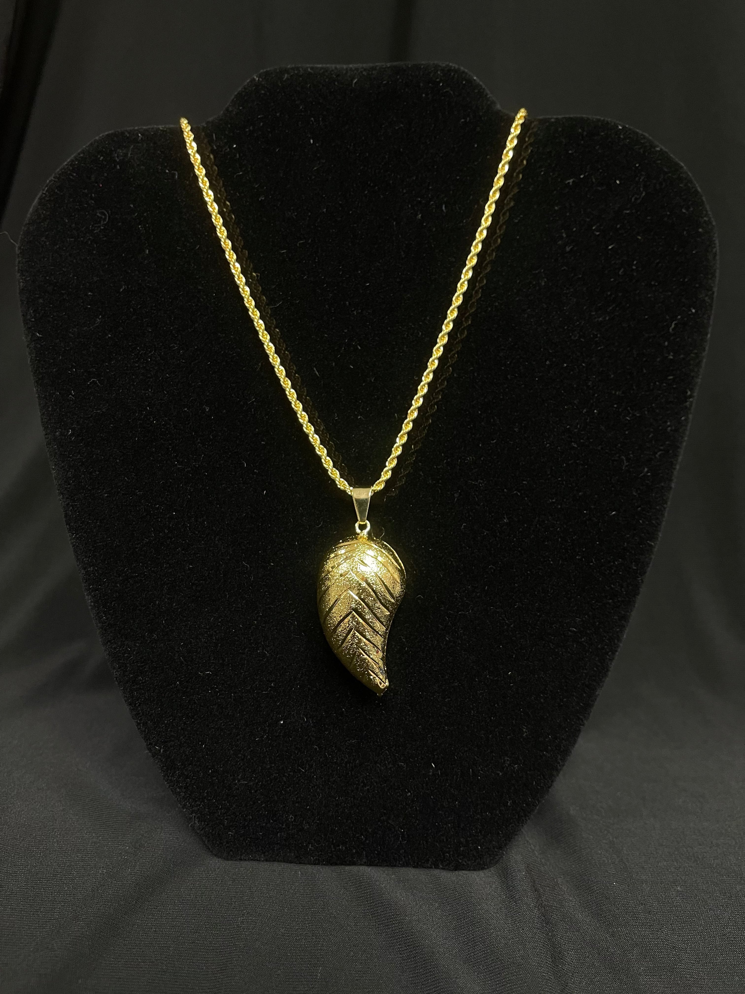 Large Almond Pendant imitated gold necklace by Palestinian Elegance displayed on black stand