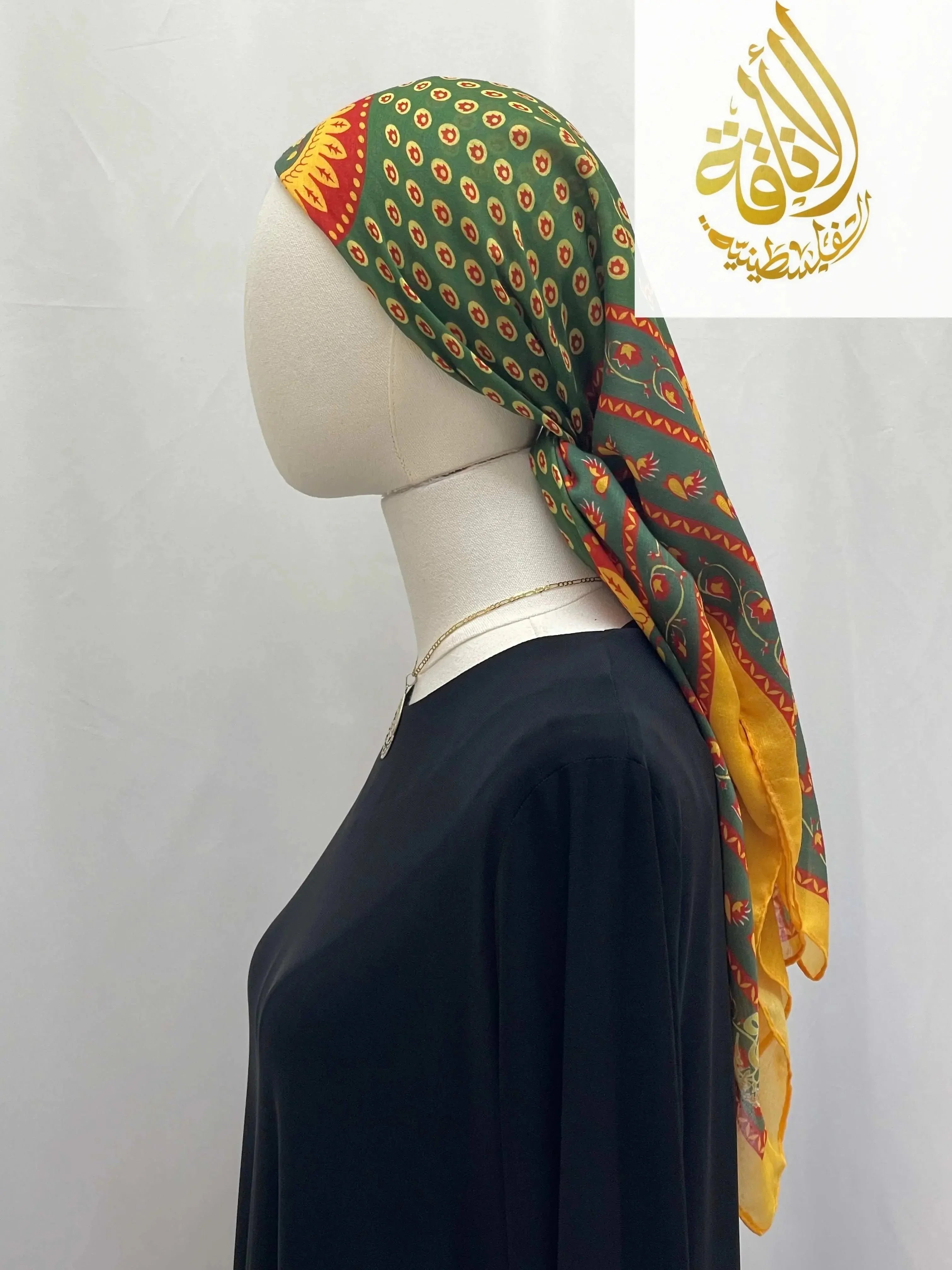 Palestinian Elegance Large Square Siti Asba hijab in green and yellow worn on mannequin