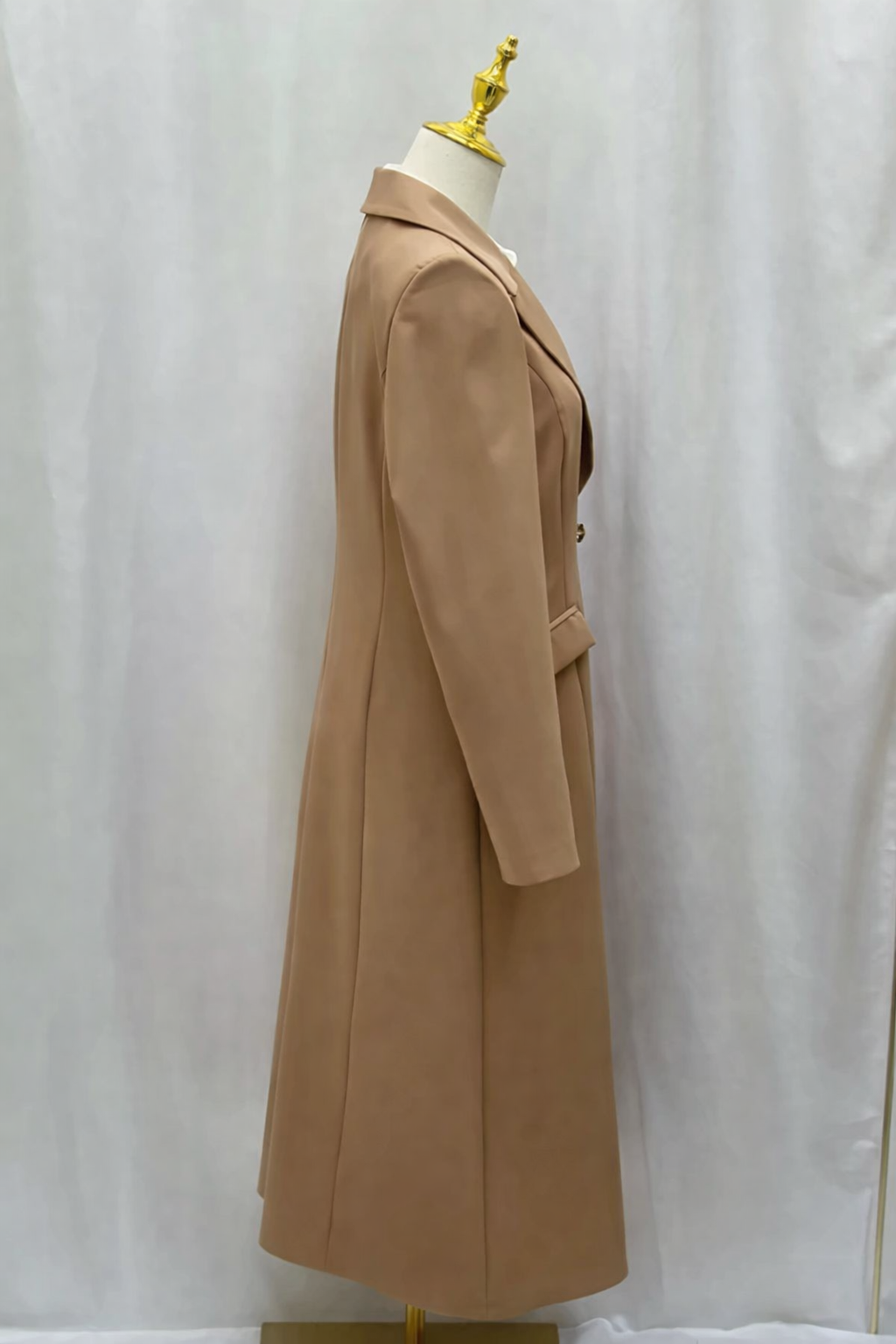 Beige coat on a mannequin against a white background