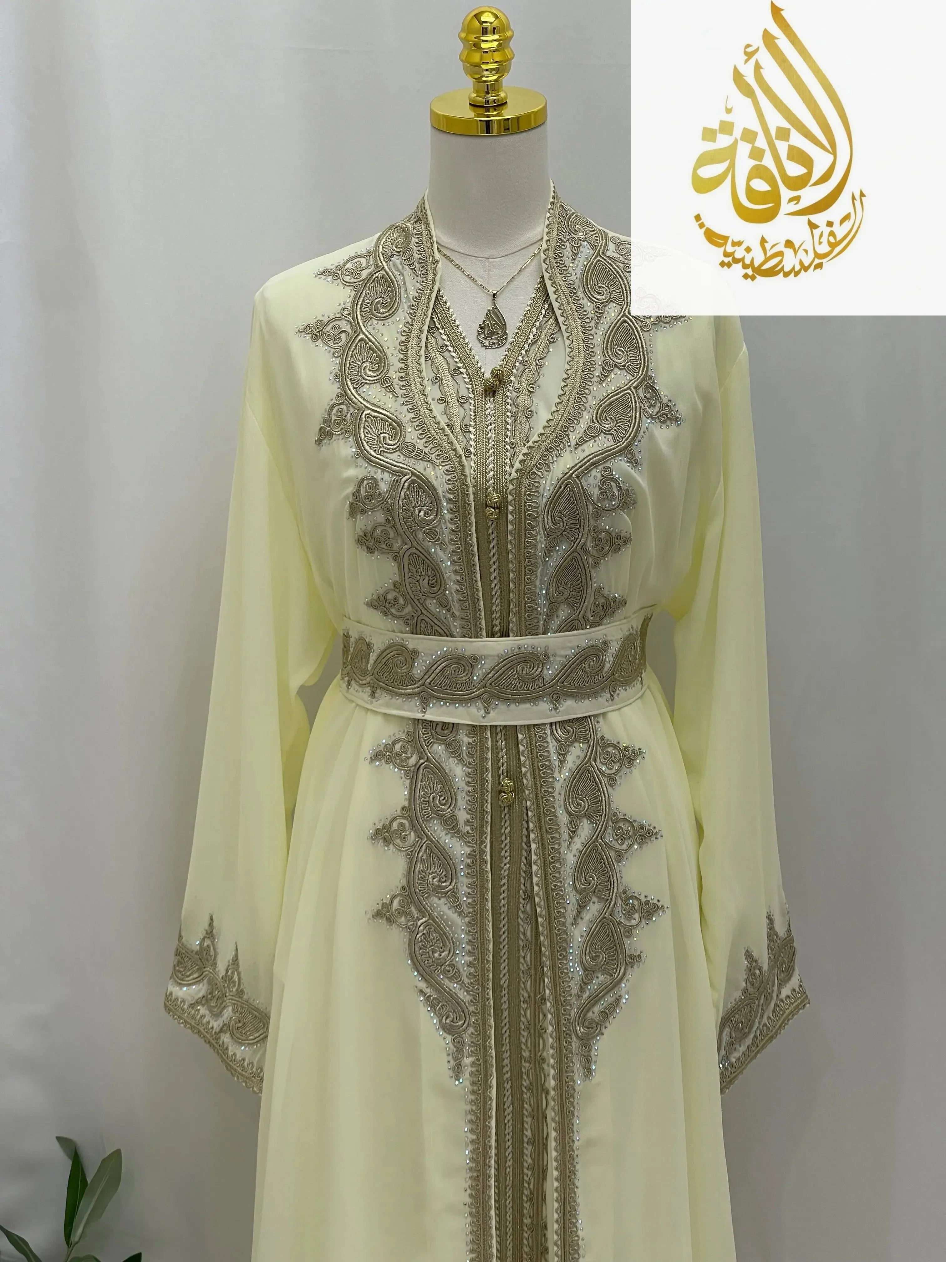 Luxurious Alamera kaftan by Palestinian Elegance in light cream with intricate silver embroidery and matching belt