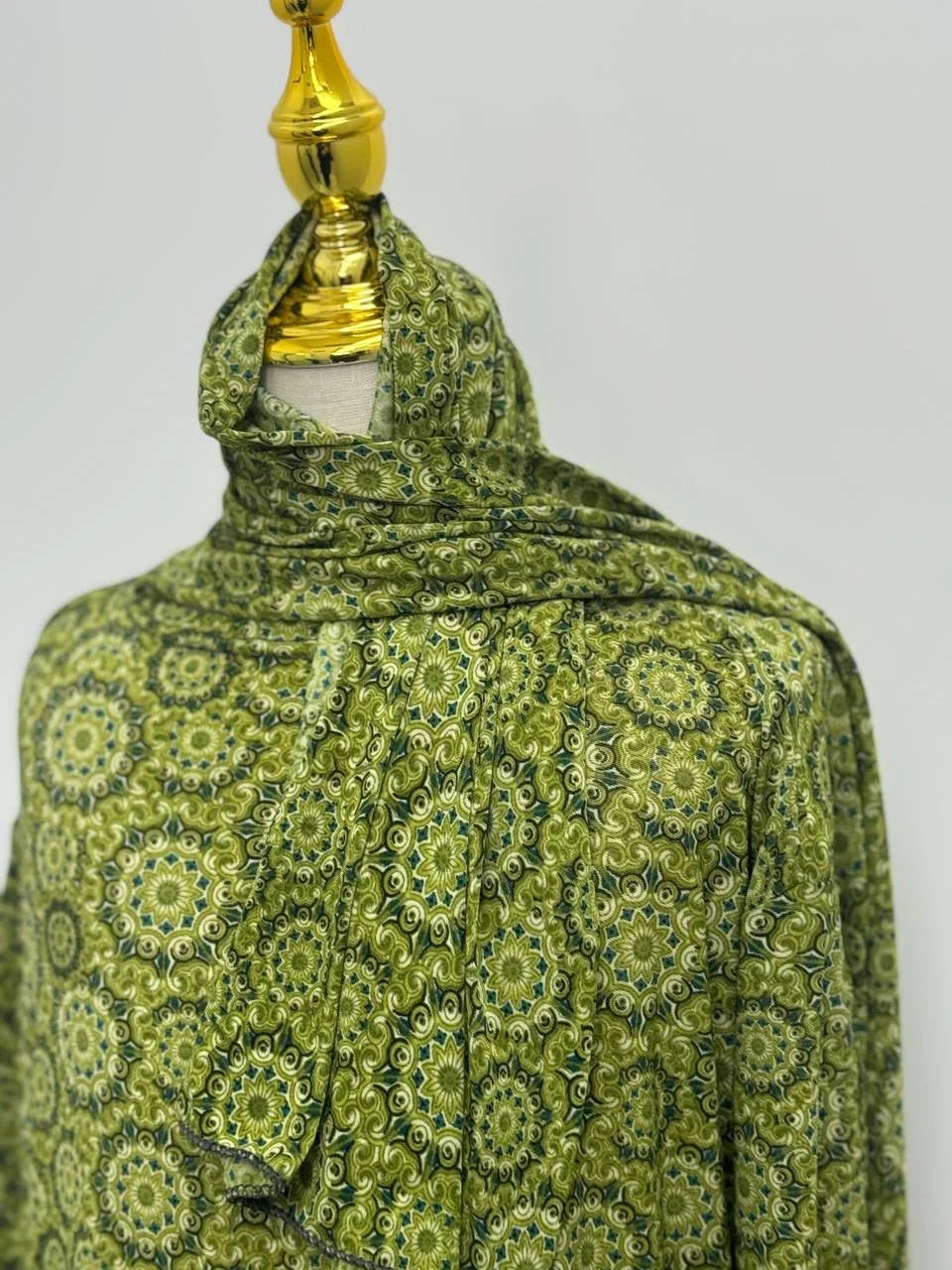 Palestinian Elegance green patterned Full Prayer Dress on mannequin with gold headpiece for modest coverage