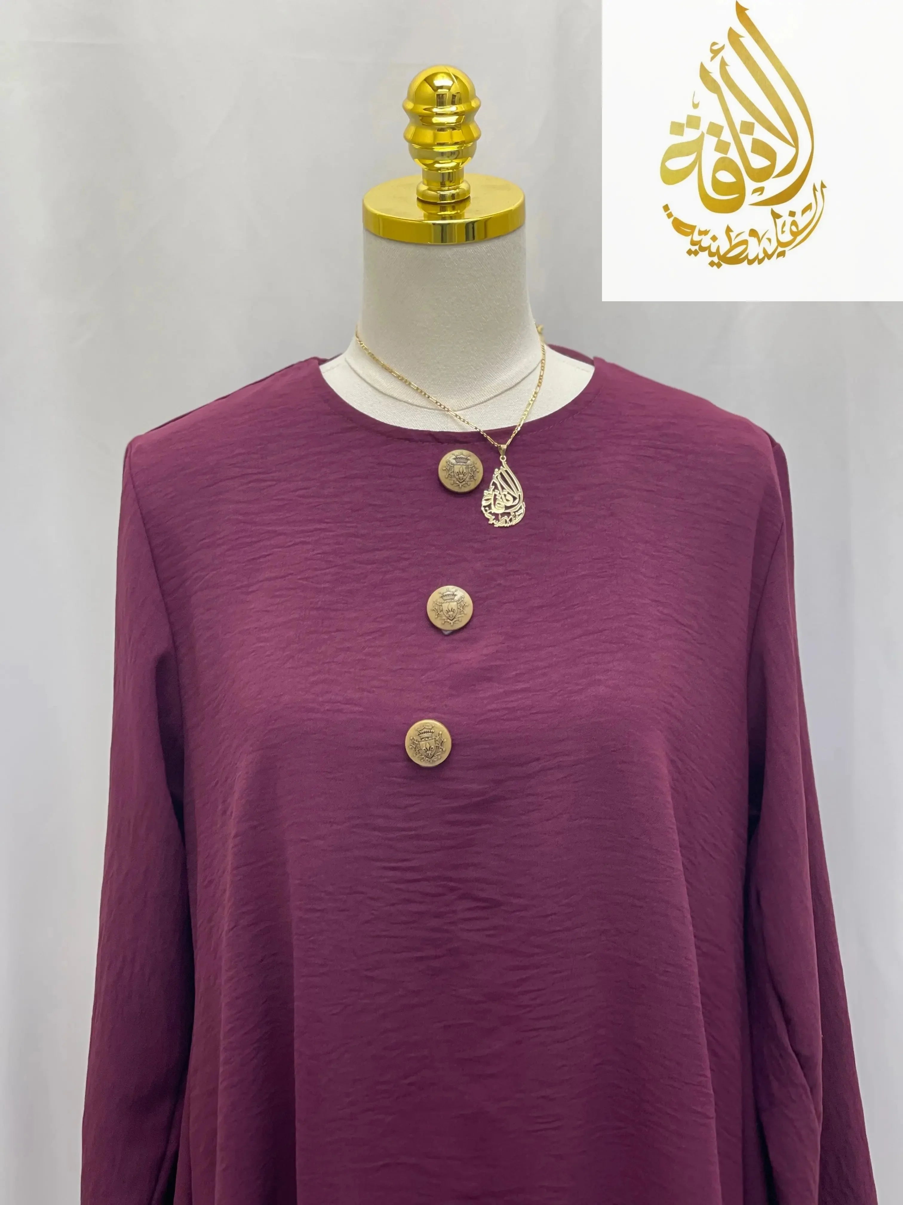 Palestinian Elegance modest long tunic and pant set in deep purple with decorative buttons on a mannequin