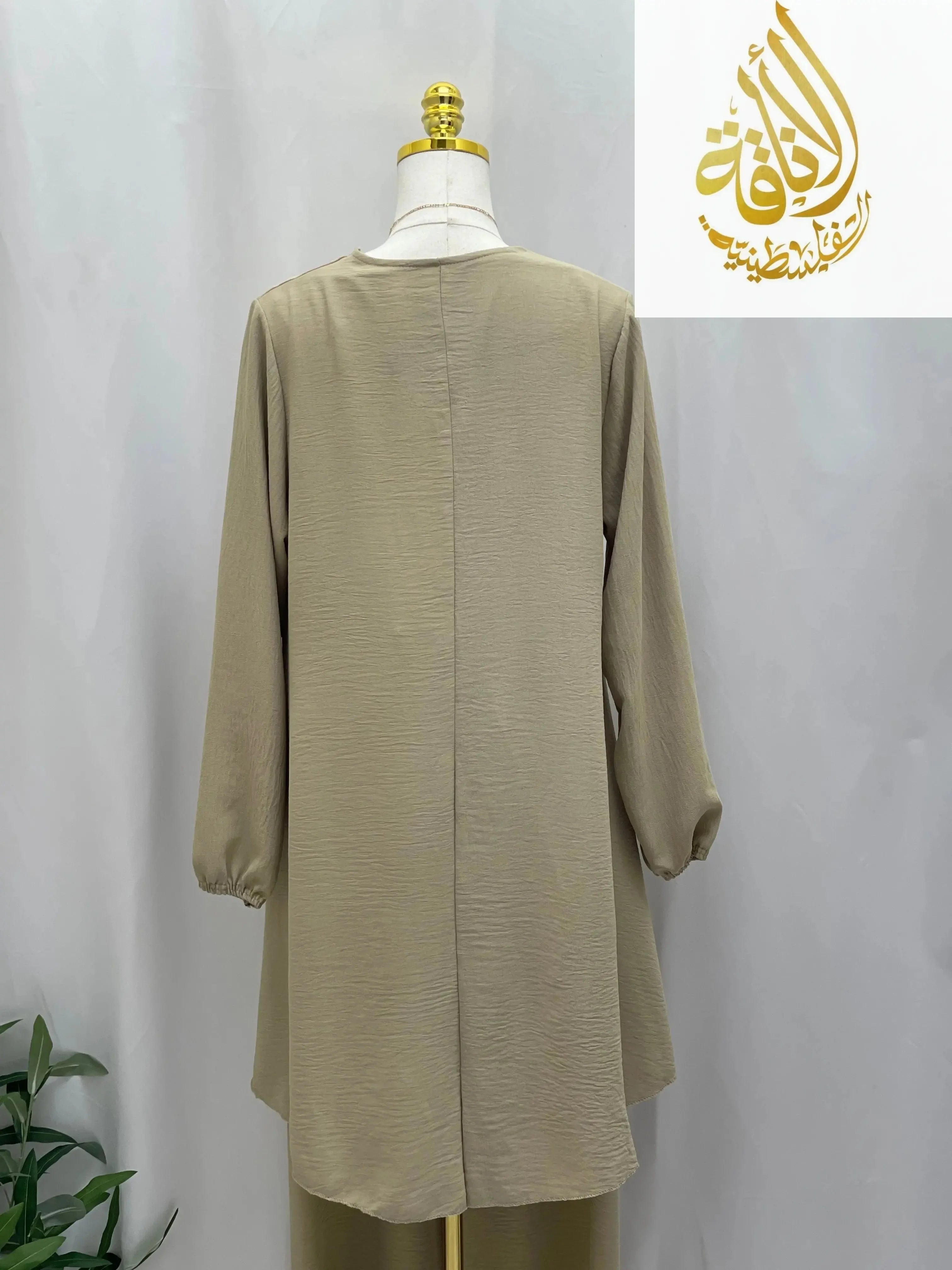 Back view of modest long tunic and pant set in beige with long sleeves displayed on mannequin