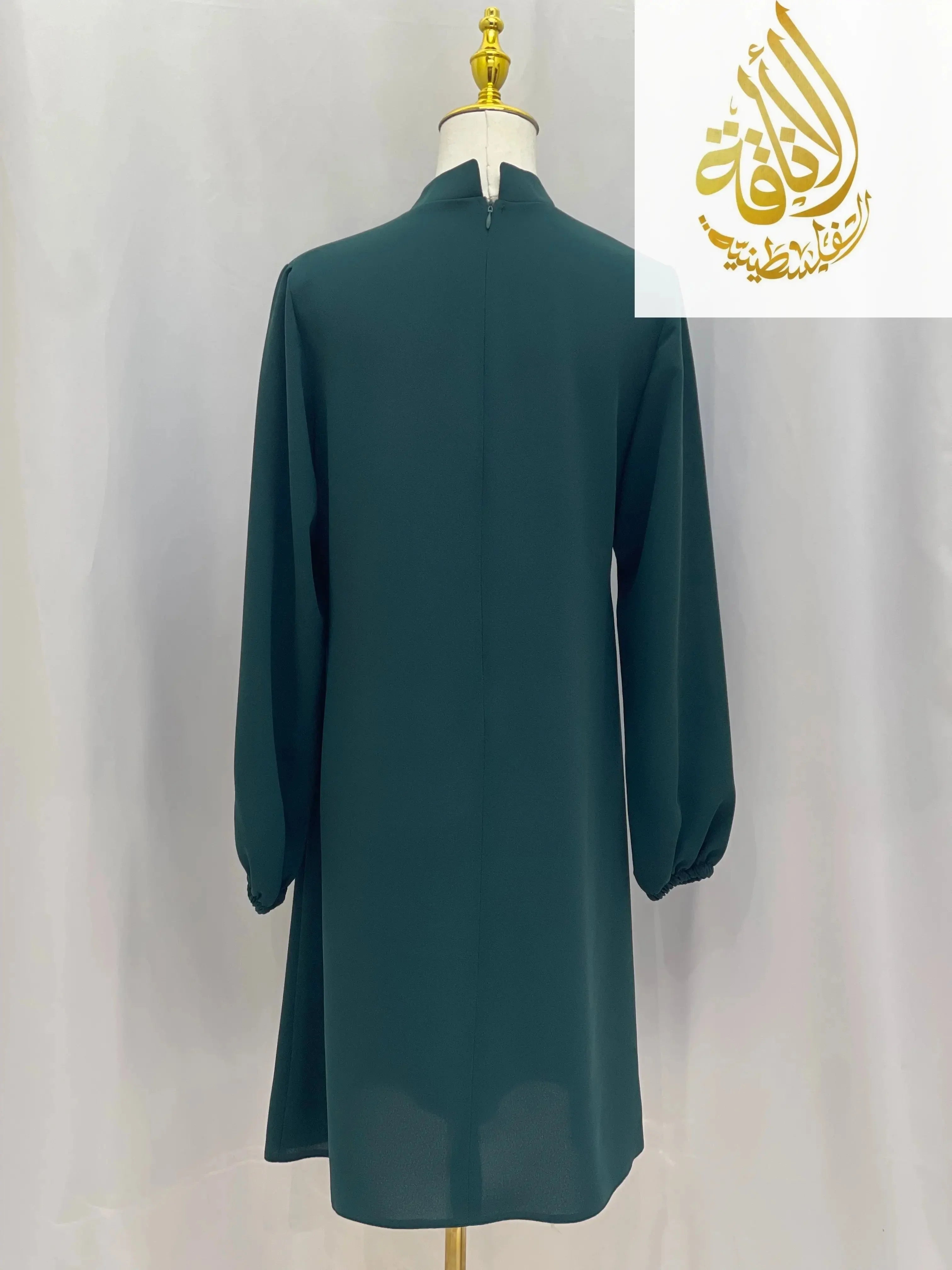 Back view of a modest embroidered tunic dress in dark green with long sleeves from Palestinian Elegance