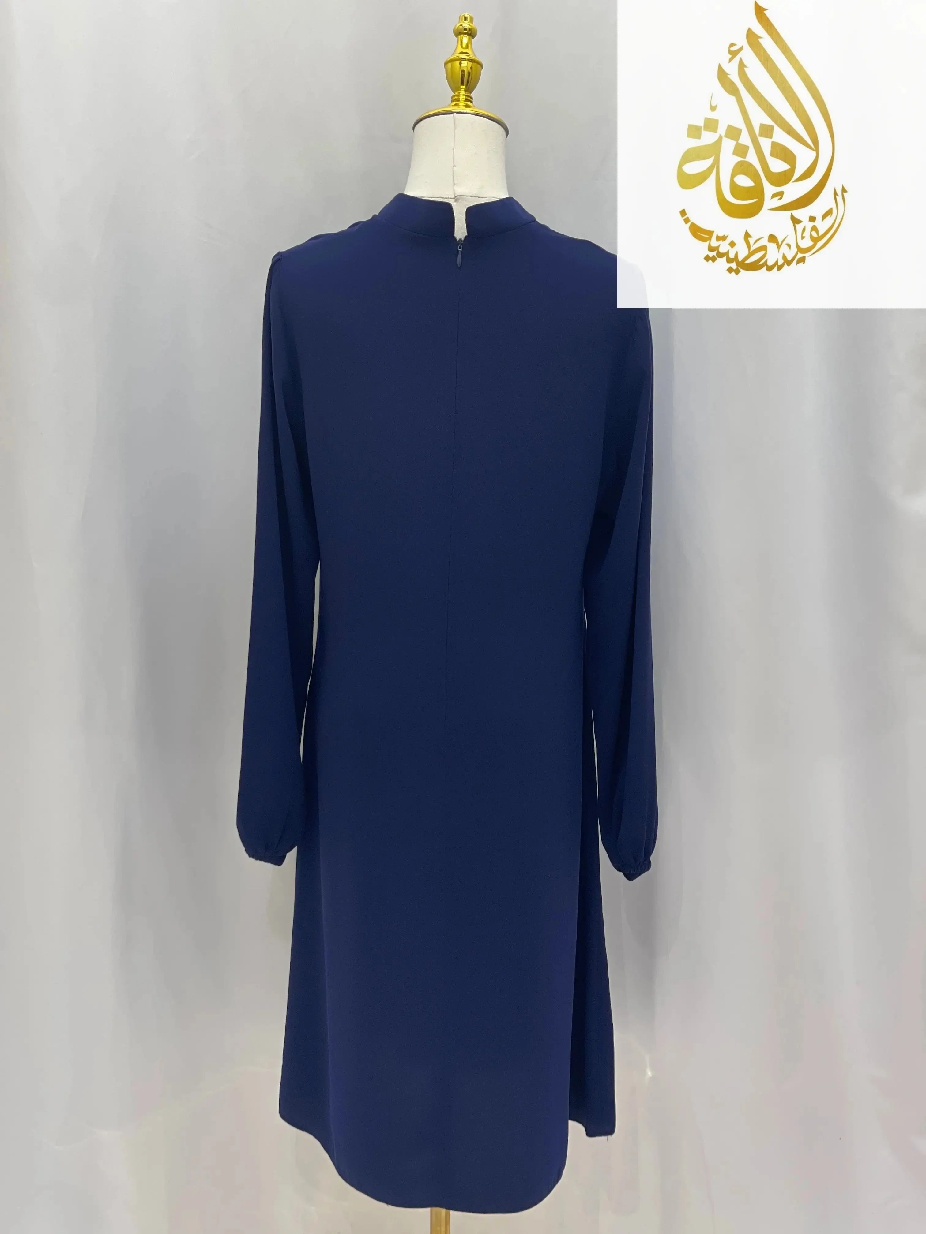 Back view of a navy modest embroidered tunic dress with long sleeves by Palestinian Elegance