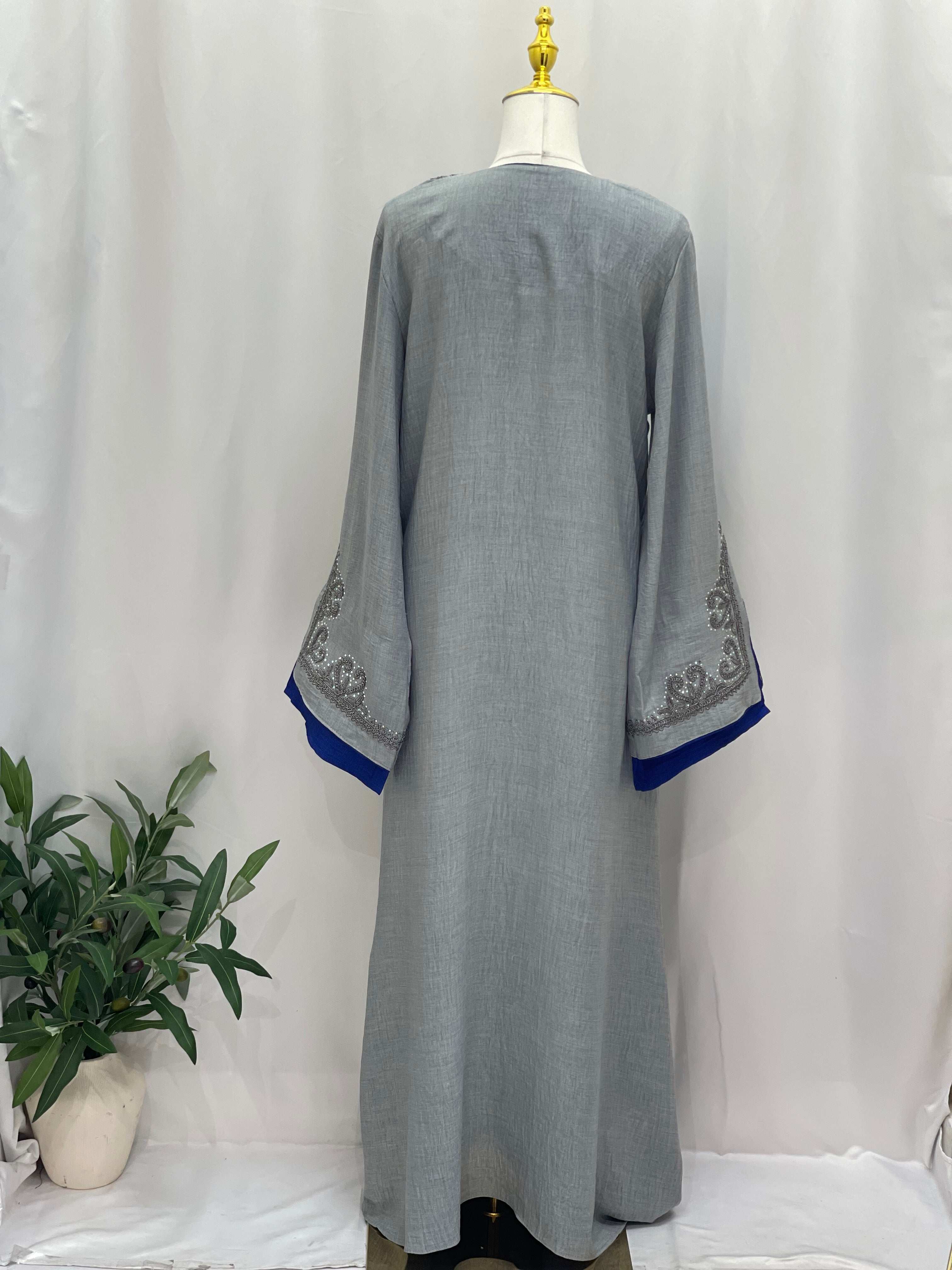 Back view of Moroccan Rana Jalabia abaya in gray with blue sleeve edges and intricate sleeve embroidery
