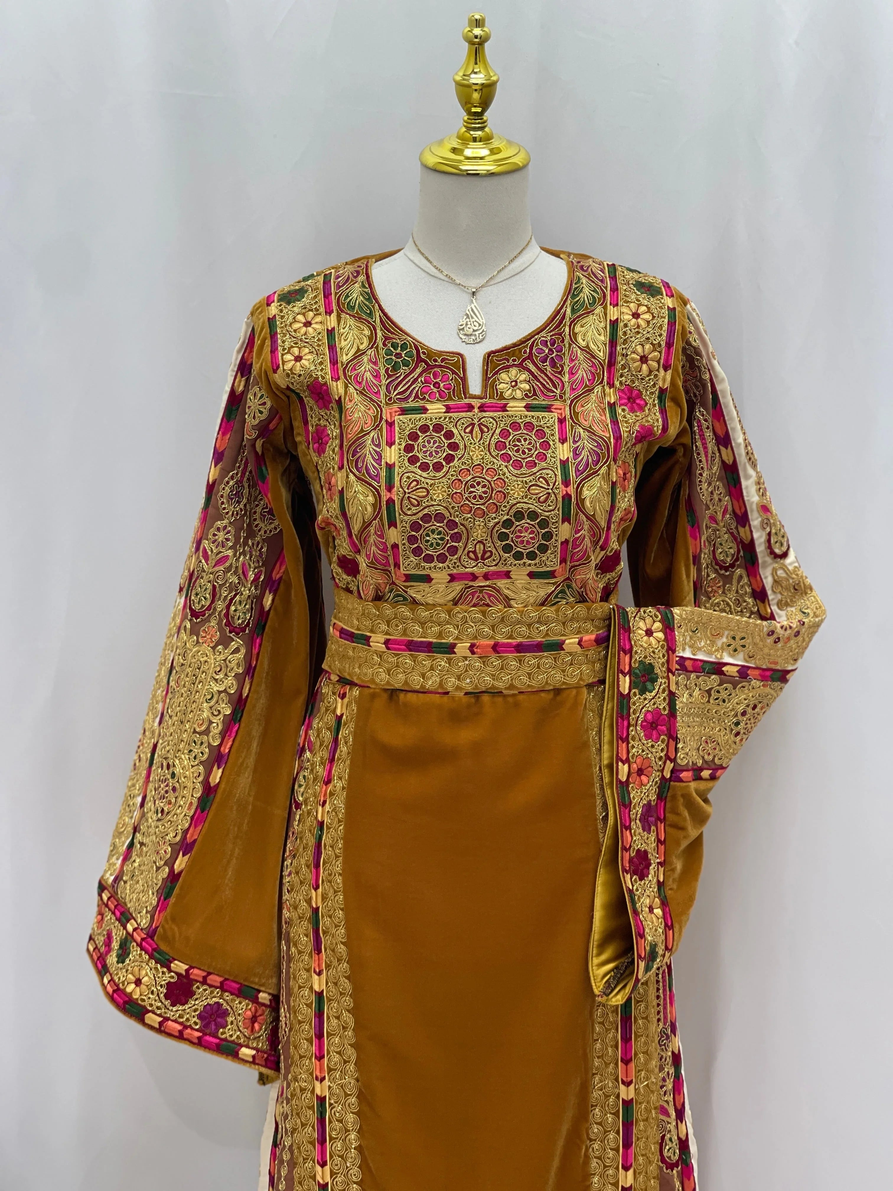 Traditional Malaka Embroidered Thoub by Palestinian Elegance featuring intricate gold and pink embroidery on a mustard fabric