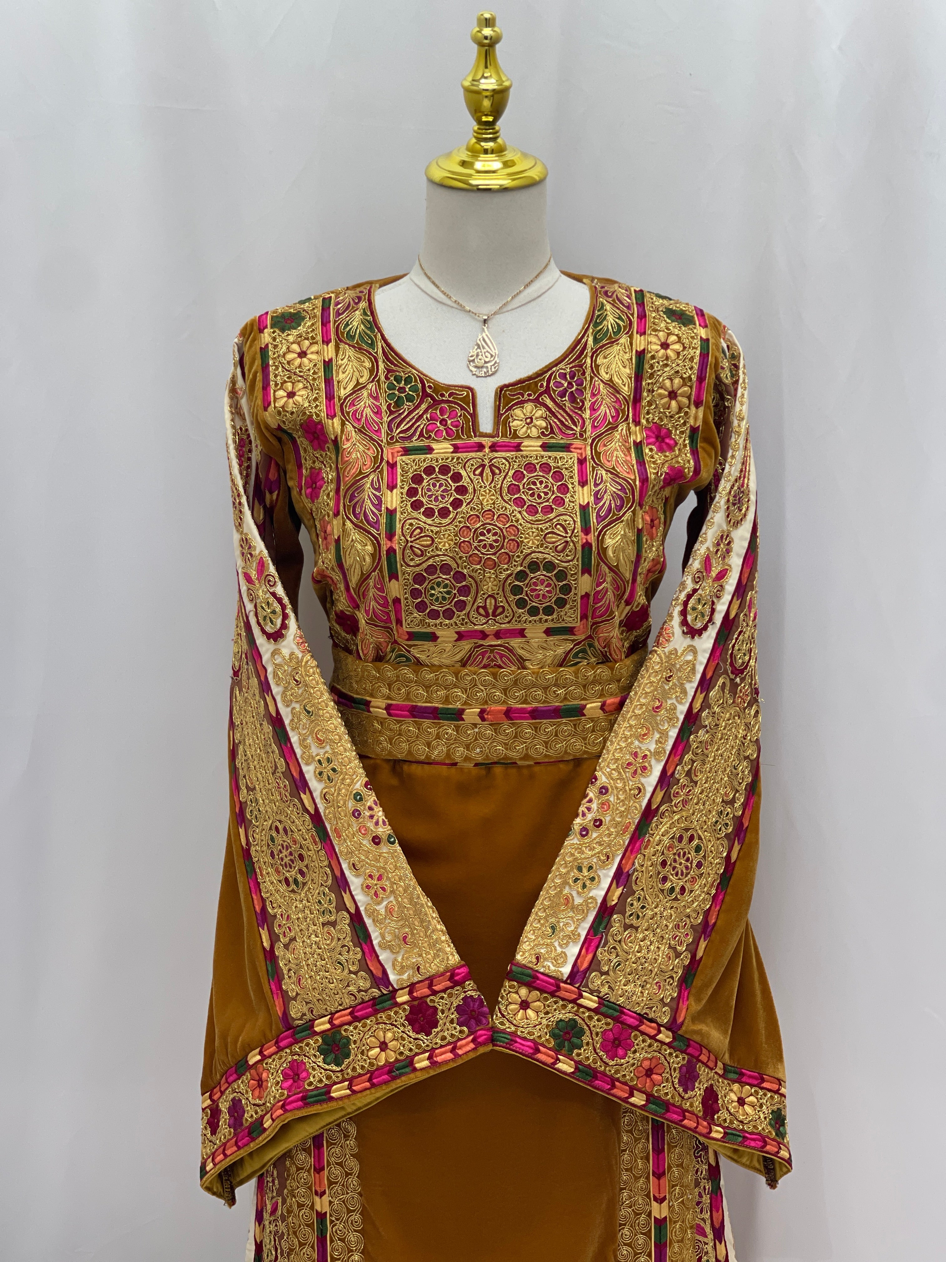Traditional Malaka Embroidered Thoub by Palestinian Elegance with intricate gold and pink embroidery on brown fabric