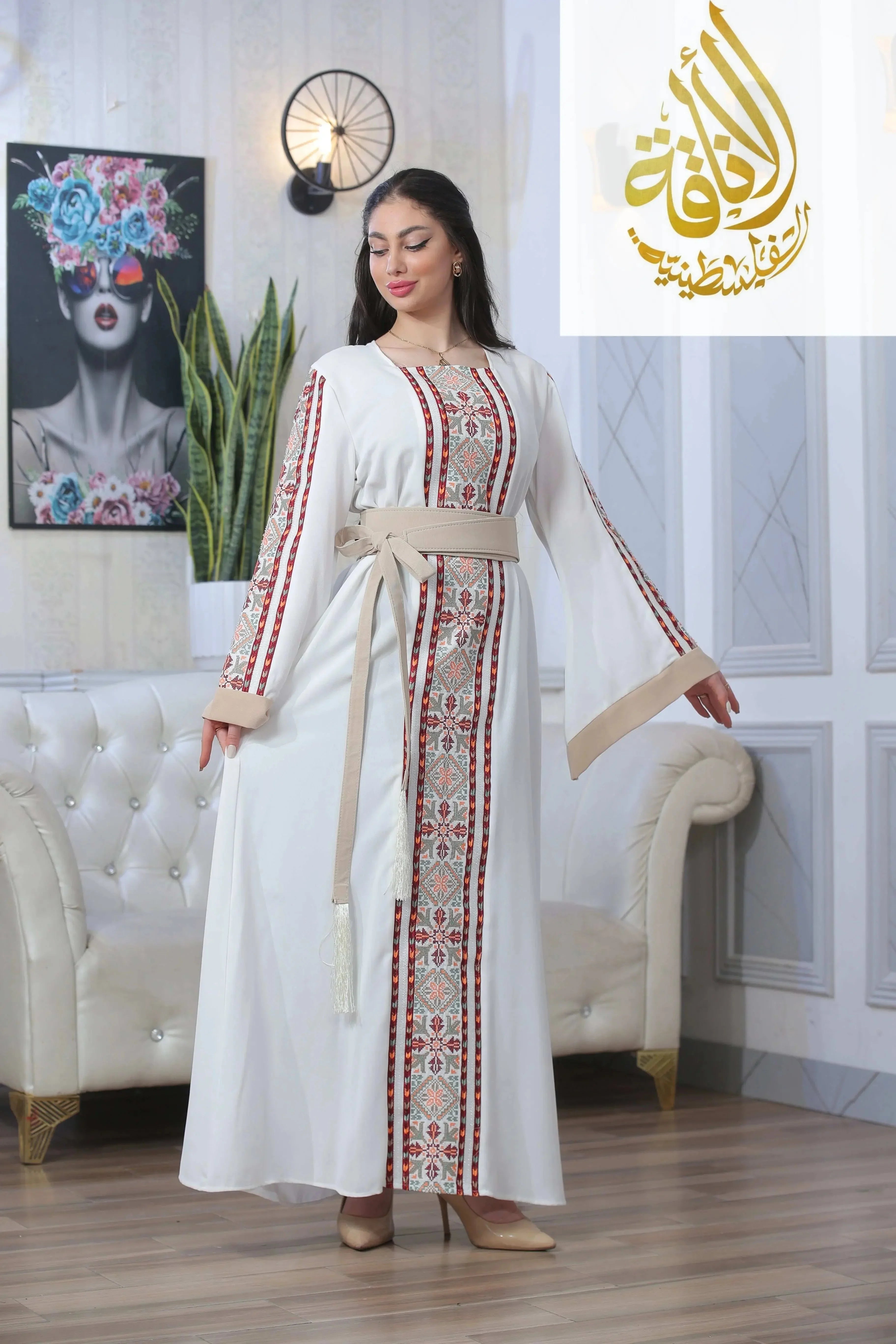 Woman wearing a white Nadera Embroidered Thoub with traditional red and beige patterns from Palestinian Elegance