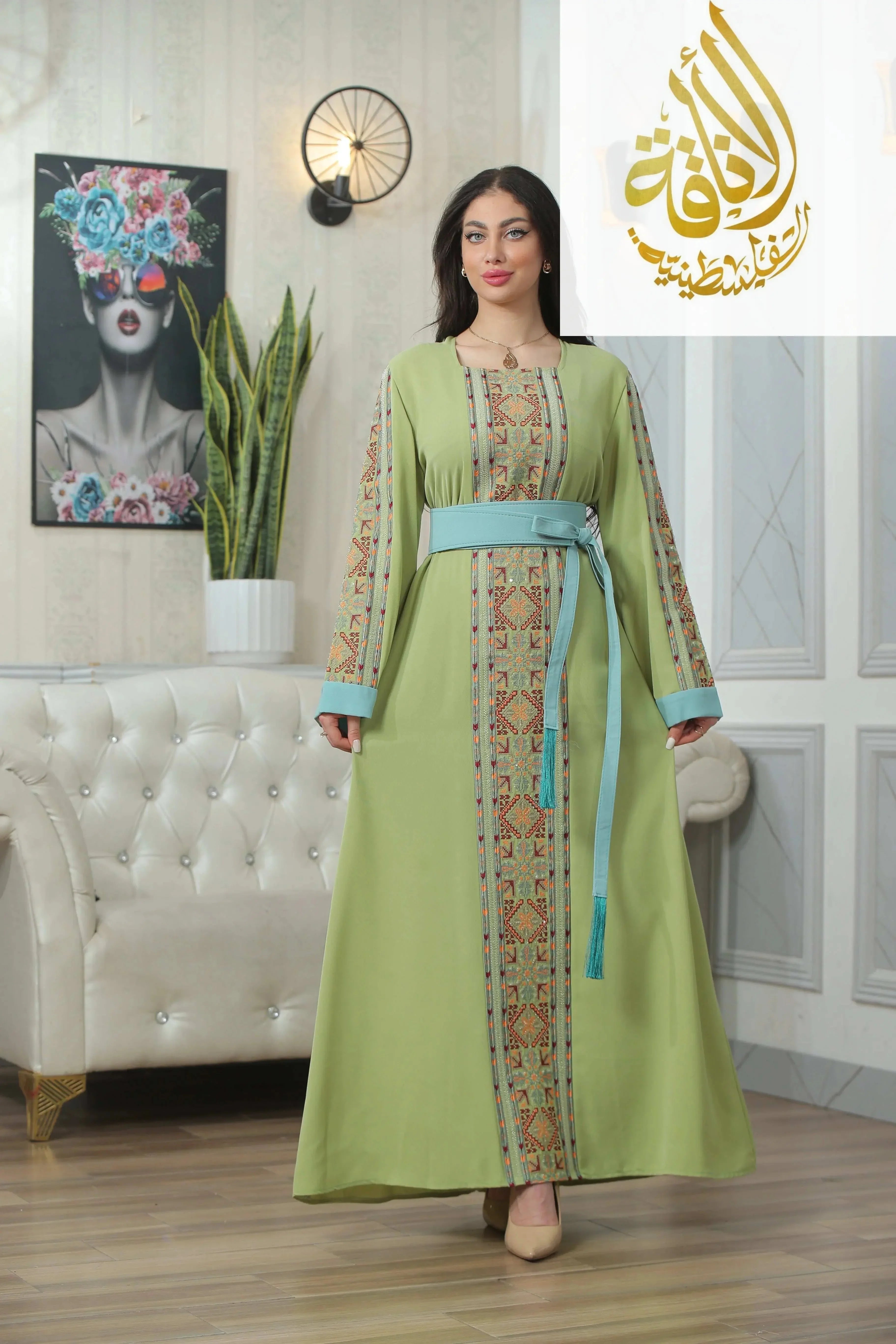 Palestinian Elegance Nadera Embroidered Thoub in light green with intricate embroidery and blue waist belt