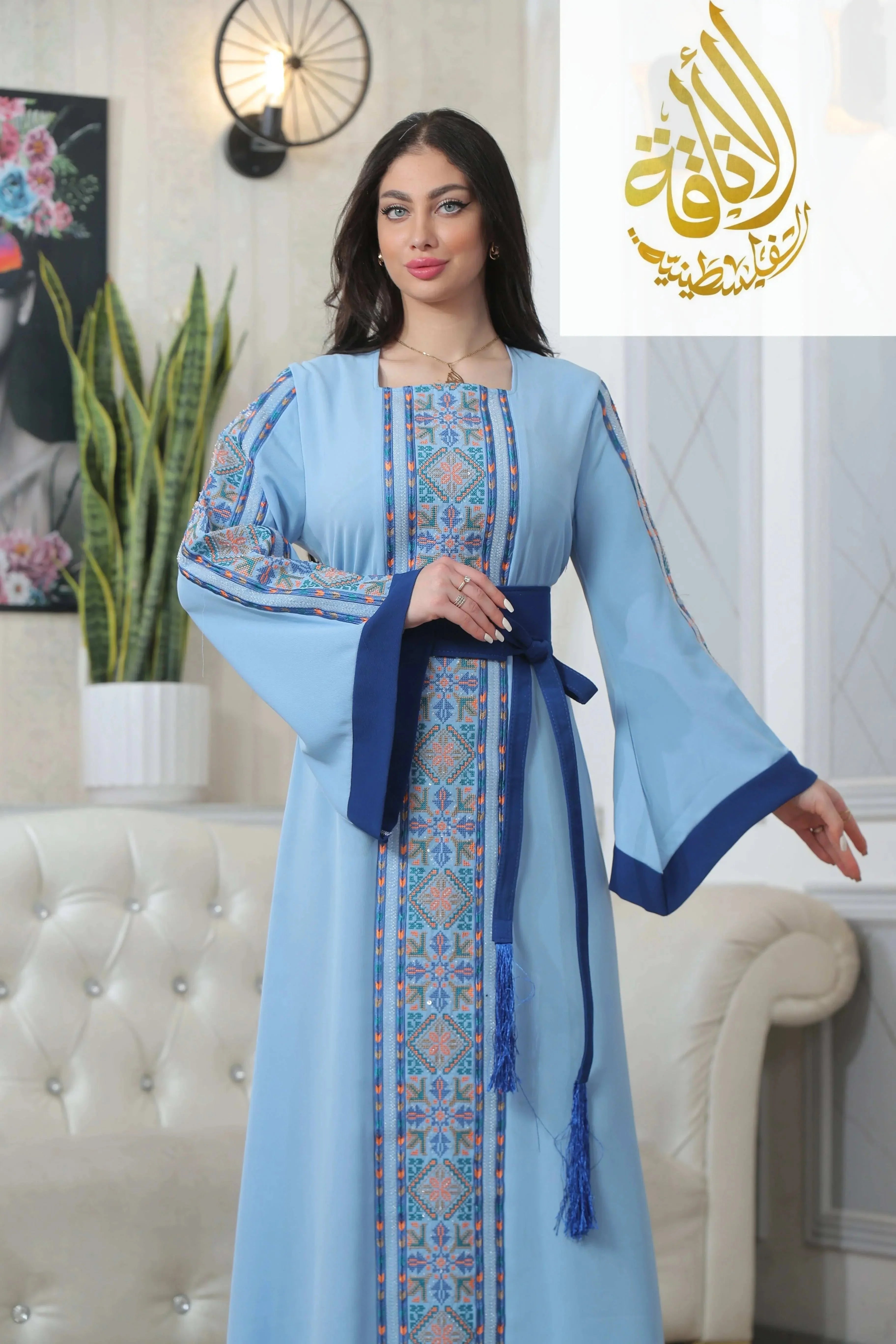 Palestinian Elegance Nadera Embroidered Thoub in light blue with detailed traditional embroidery and dark blue belt