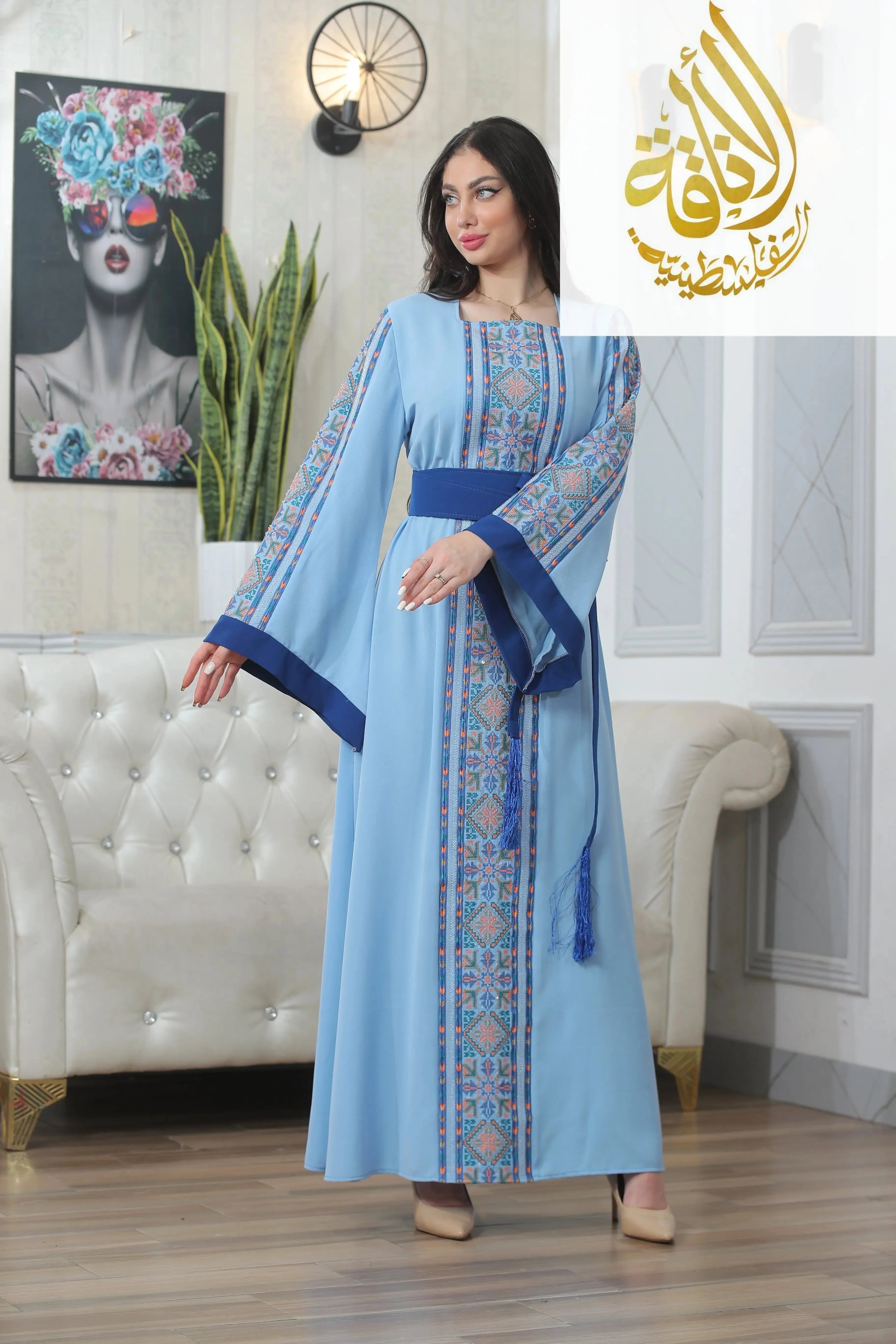 Palestinian Elegance Nadera Embroidered Thoub in light blue with intricate embroidery and navy sash belt